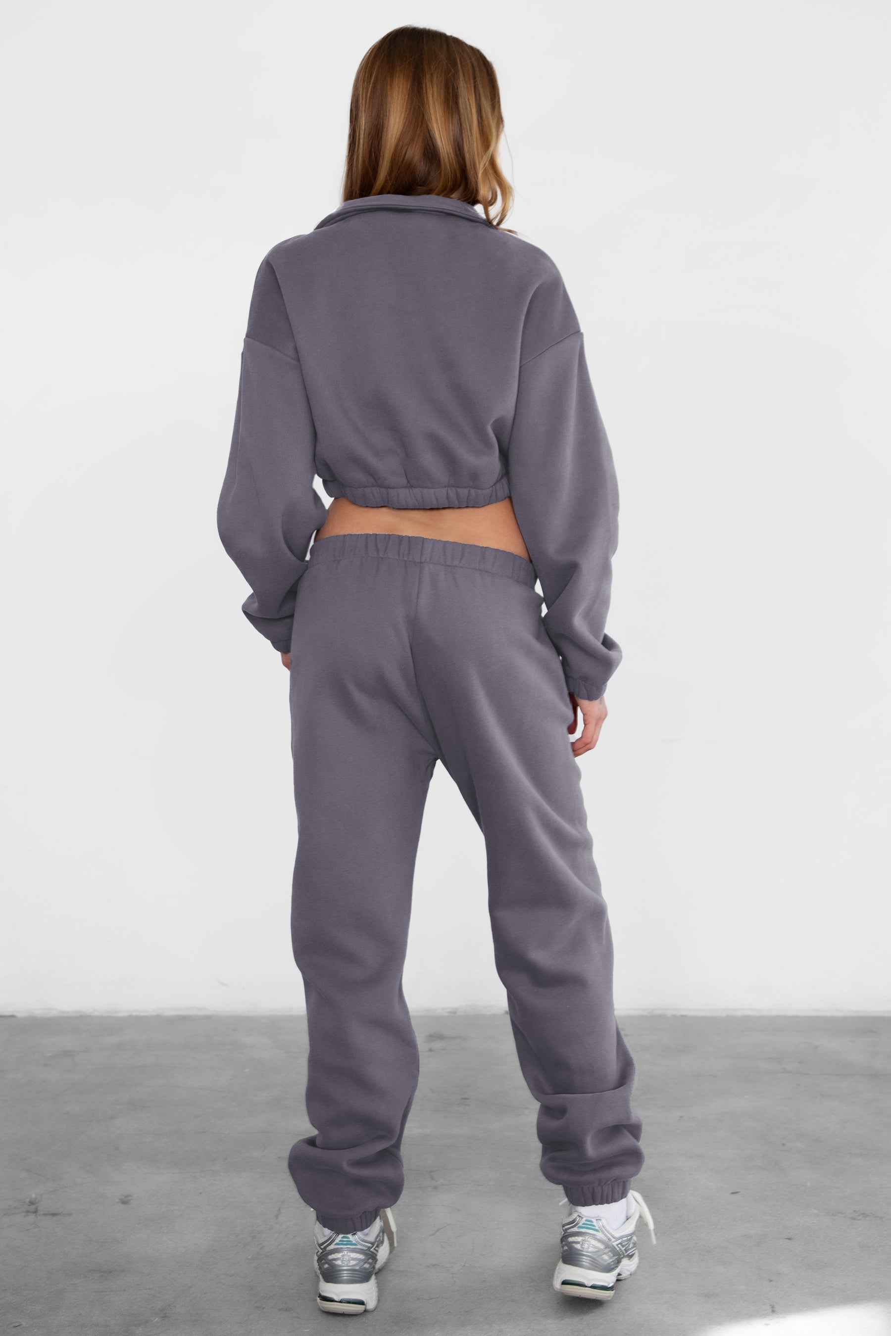 Woman wearing the TIC TOC PH26027 DOVE charcoal high waist sweatpants featuring an elastic waistband, deep side pockets, and tapered ankle hem with a matching top.