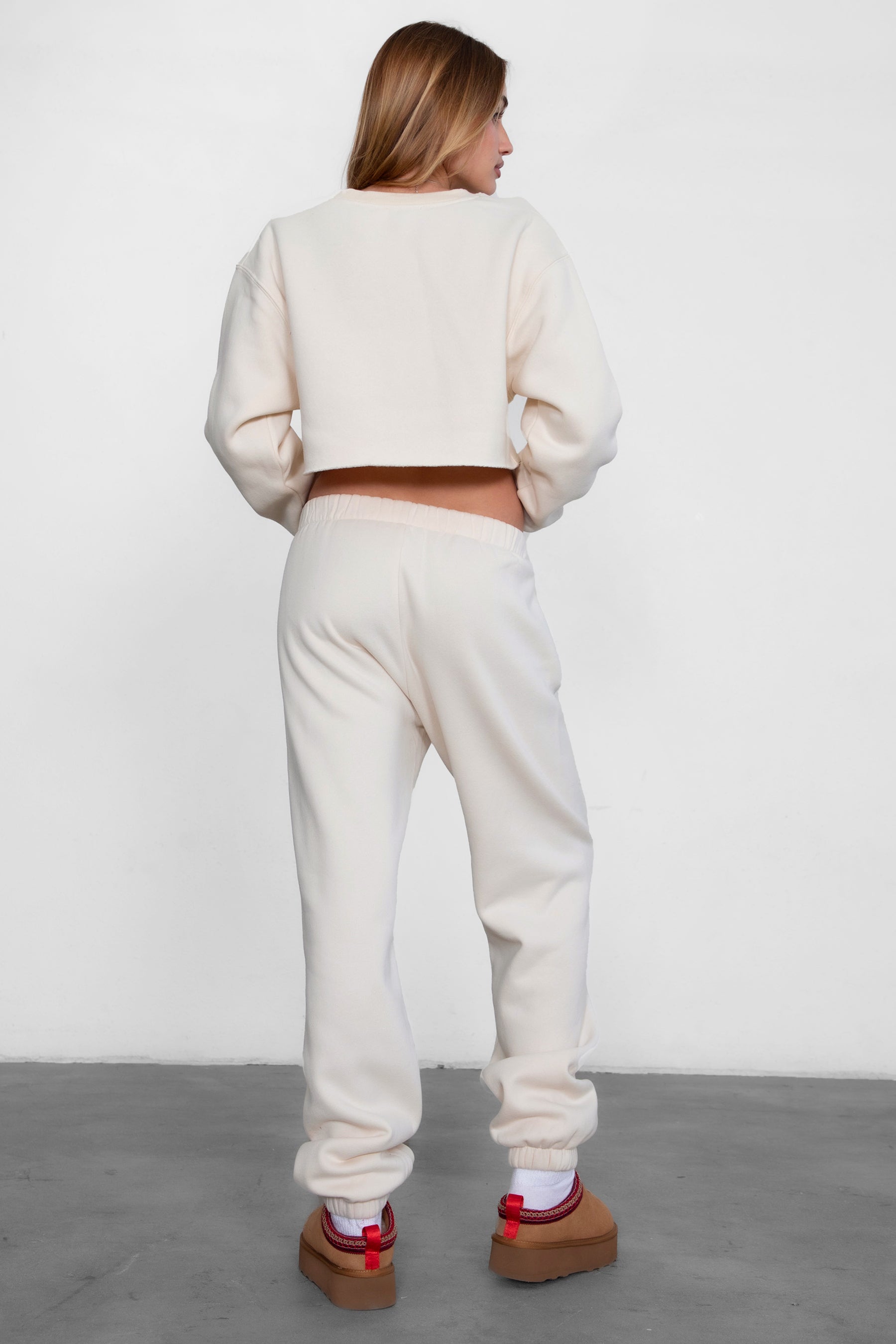Woman wearing the TIC TOC PH26027 DOVE ecru high waist sweatpants featuring an elastic waistband, deep side pockets, and tapered ankle hem with a matching top.