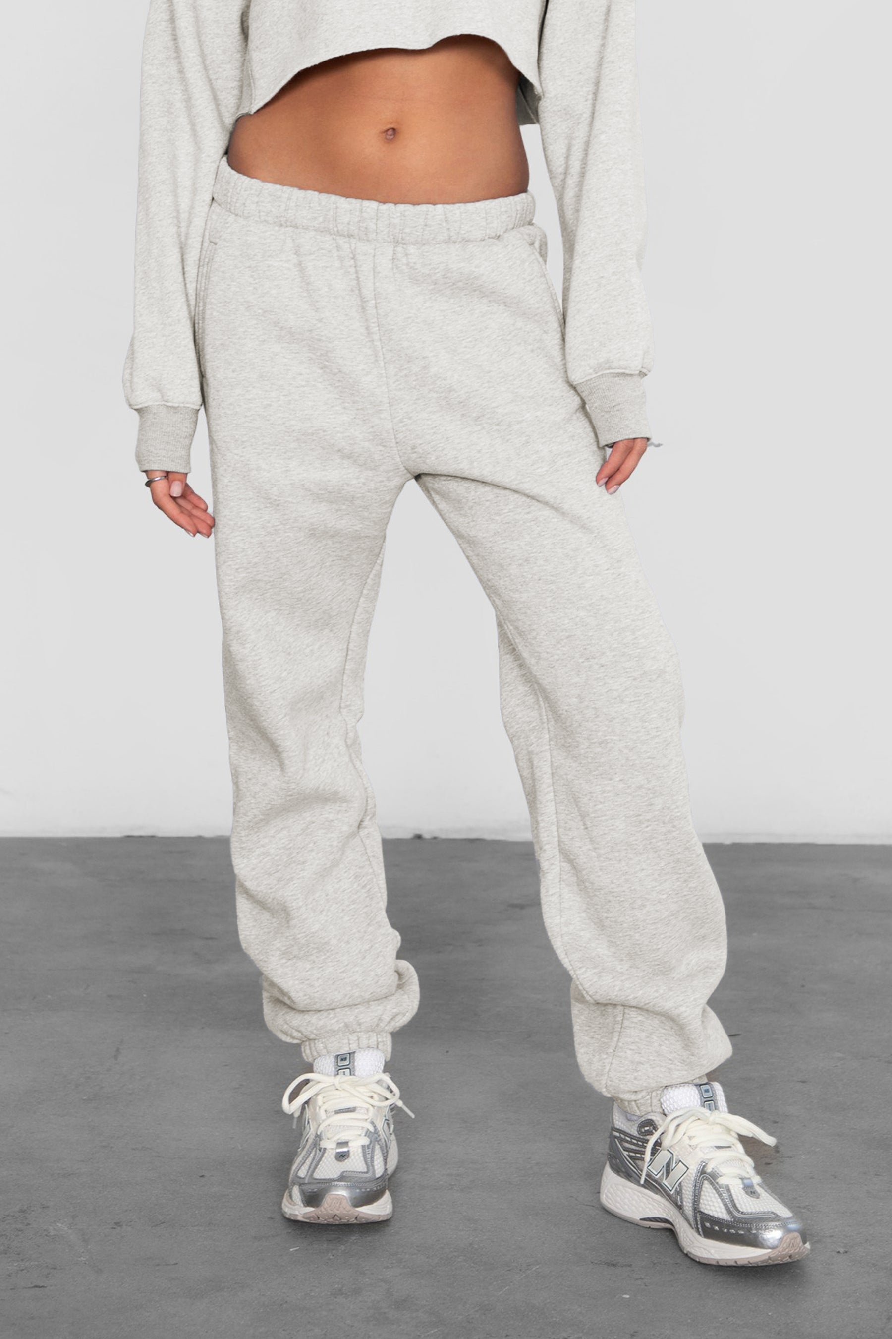 Woman wearing the TIC TOC PH26027 DOVE heather white high waist sweatpants featuring an elastic waistband, deep side pockets, and tapered ankle hem with a matching top.