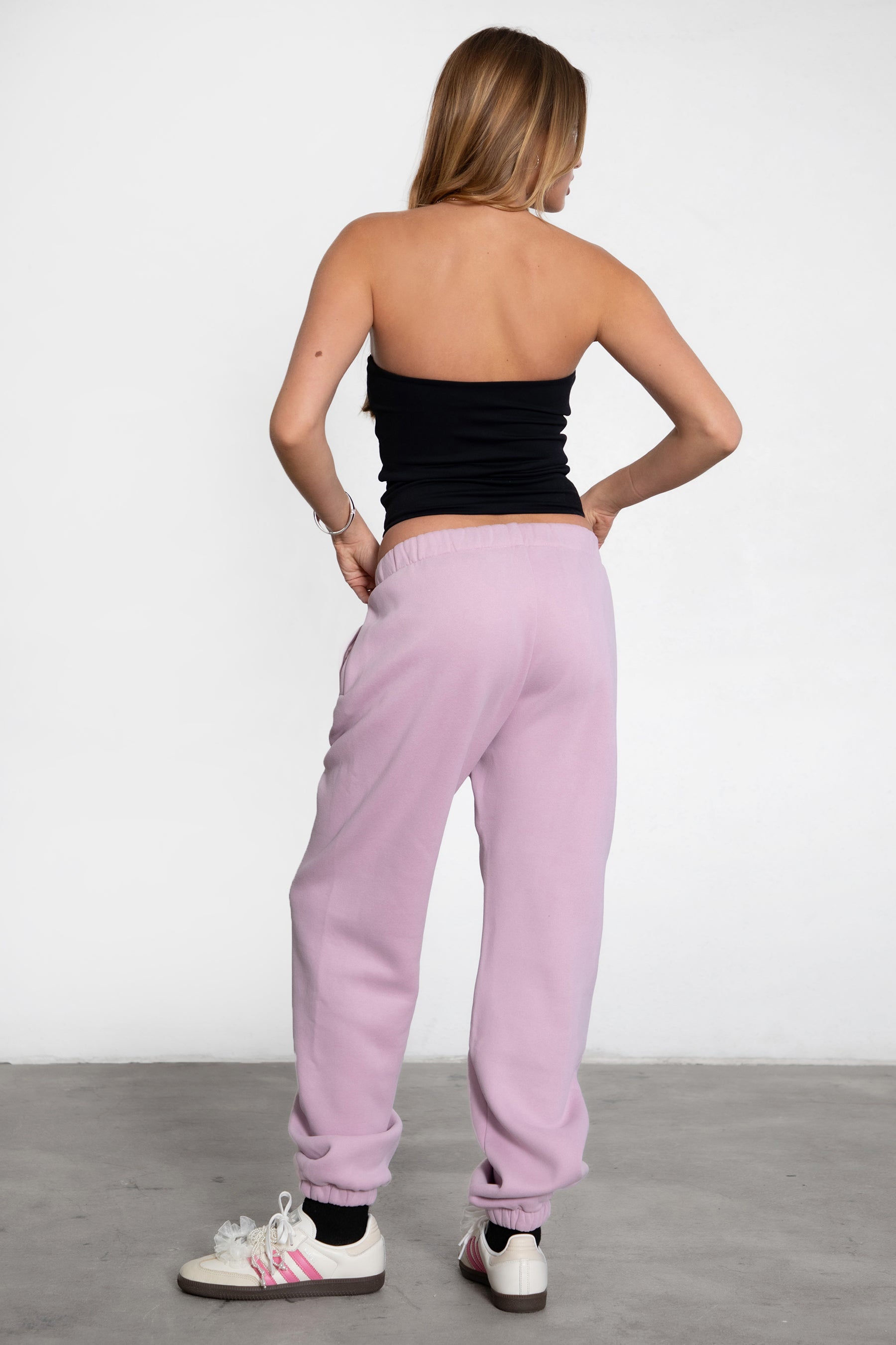 Woman wearing the TIC TOC PH26027 DOVE light lavender high waist sweatpants featuring an elastic waistband, deep side pockets, and tapered ankle hem with a matching top.