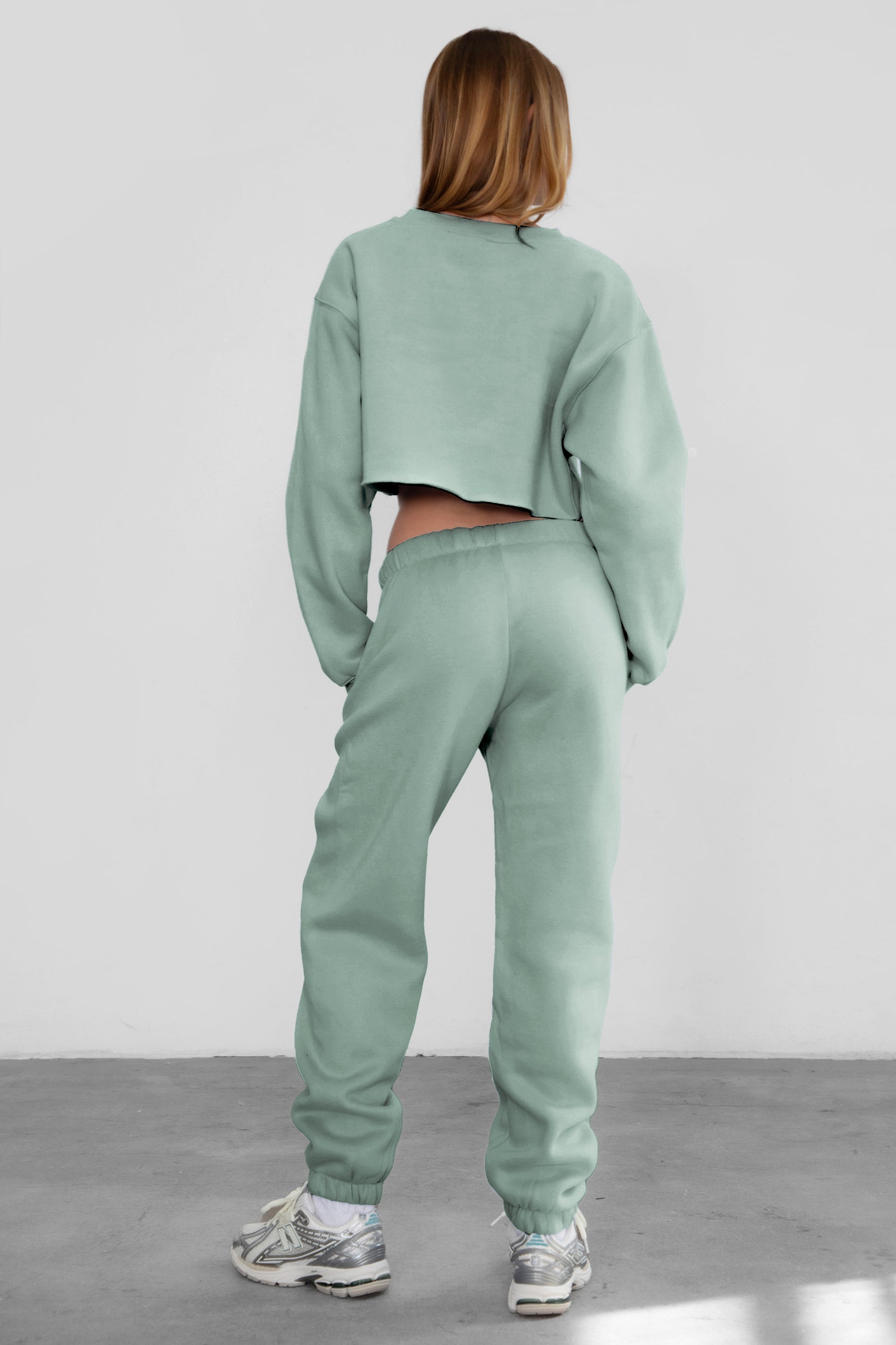 Woman wearing the TIC TOC PH26027 DOVE sage high waist sweatpants featuring an elastic waistband, deep side pockets, and tapered ankle hem with a matching top.