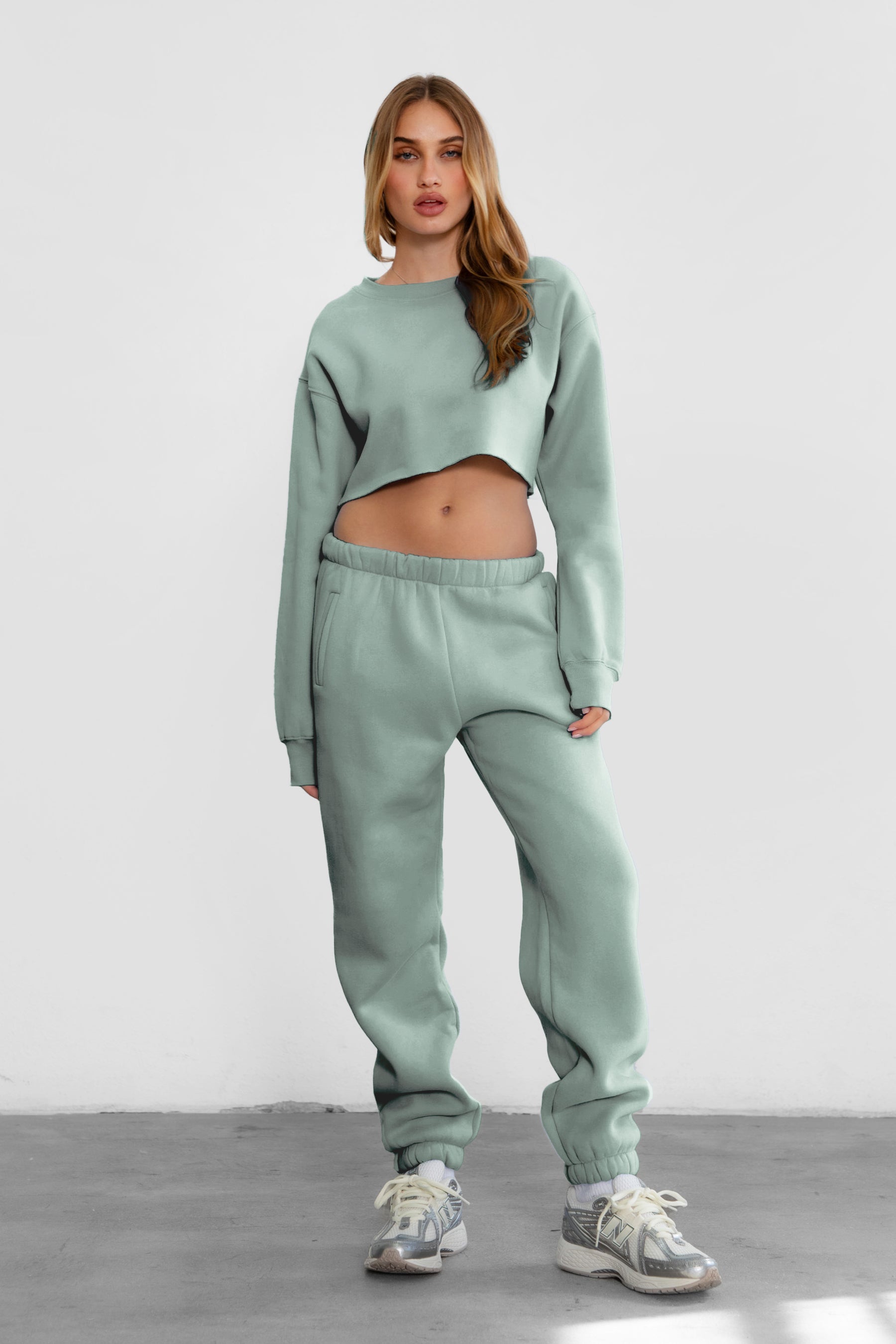 Woman wearing the TIC TOC PH26027 DOVE sage high waist sweatpants featuring an elastic waistband, deep side pockets, and tapered ankle hem with a matching top.