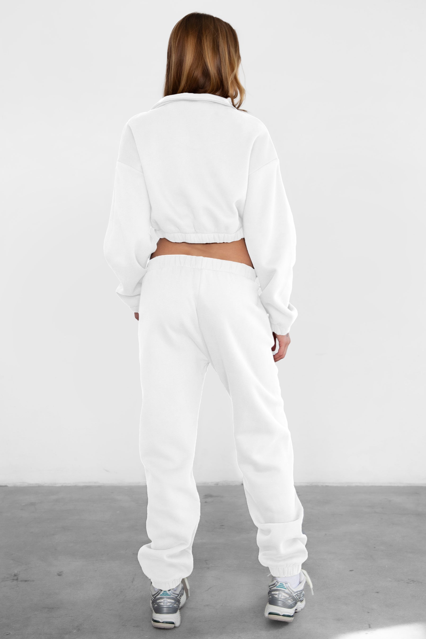 Woman wearing the TIC TOC PH26027 DOVE white high waist sweatpants featuring an elastic waistband, deep side pockets, and tapered ankle hem with a matching top.
