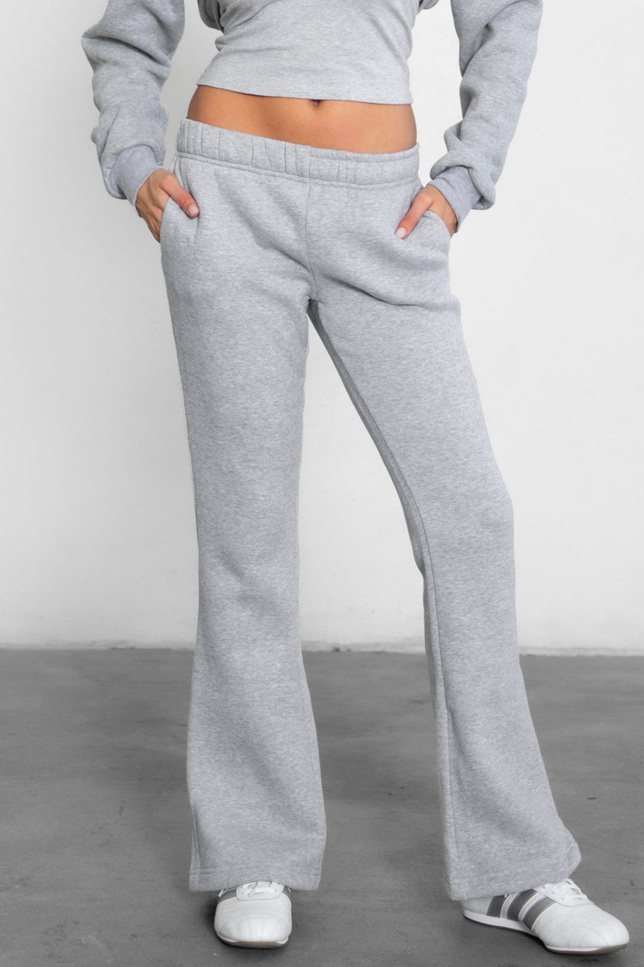 Woman wearing TIC TOC PH29142 JIYA essential fleece flare sweatpants with mid-rise waistband and side pockets from plush fleece collection in heather grey paired with a matching top and bolero.