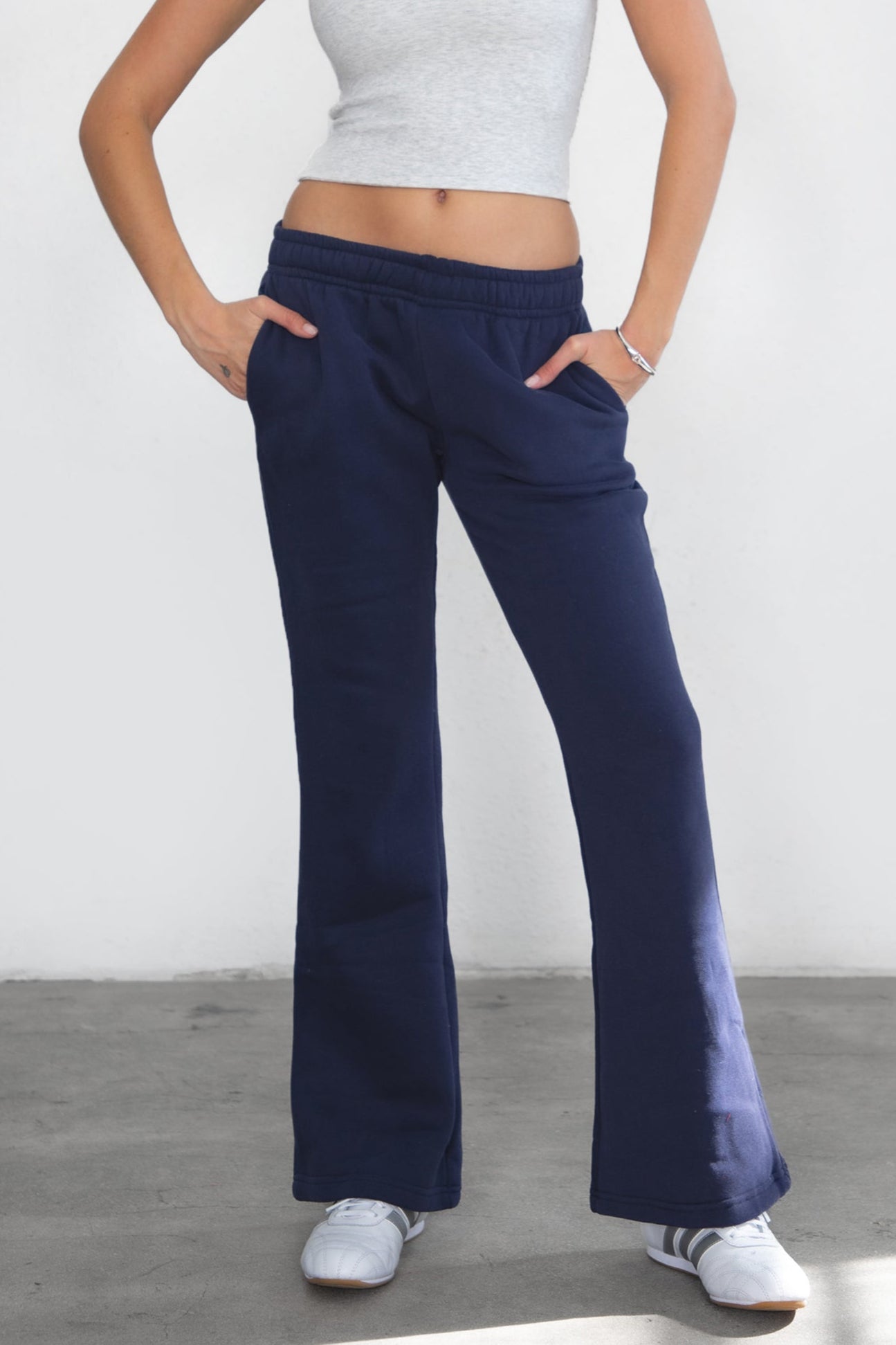 Woman wearing TIC TOC PH29142 JIYA essential fleece flare sweatpants with mid-rise waistband and side pockets from plush fleece collection in navy paired with a heather white top.