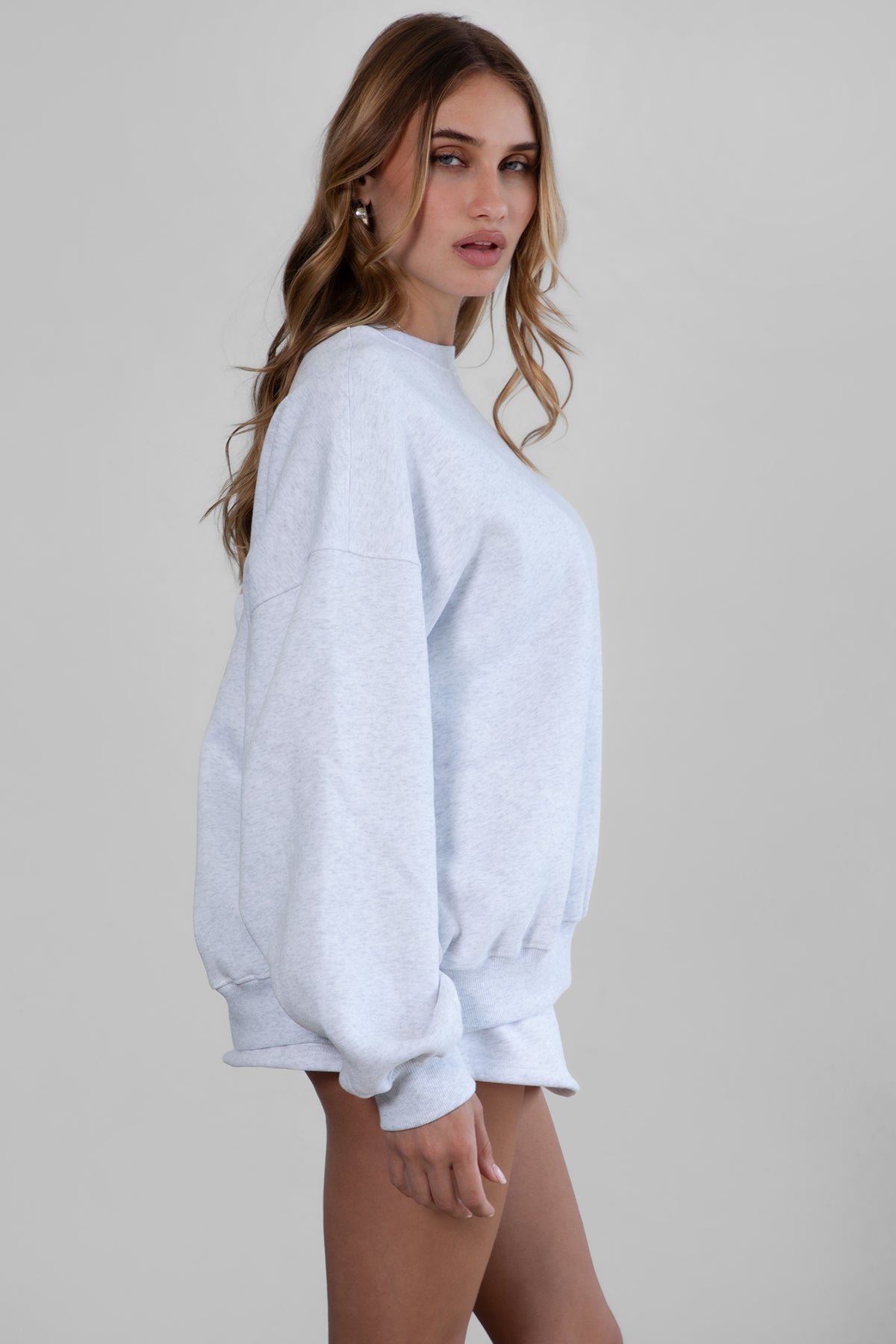 Woman wearing the TIC TOC TH28243 VARSITY ash fleece crew neck pullover sweatshirt featuring dropped shoulders, ribbed trim, and plush fleece fabric with the matching bottoms
