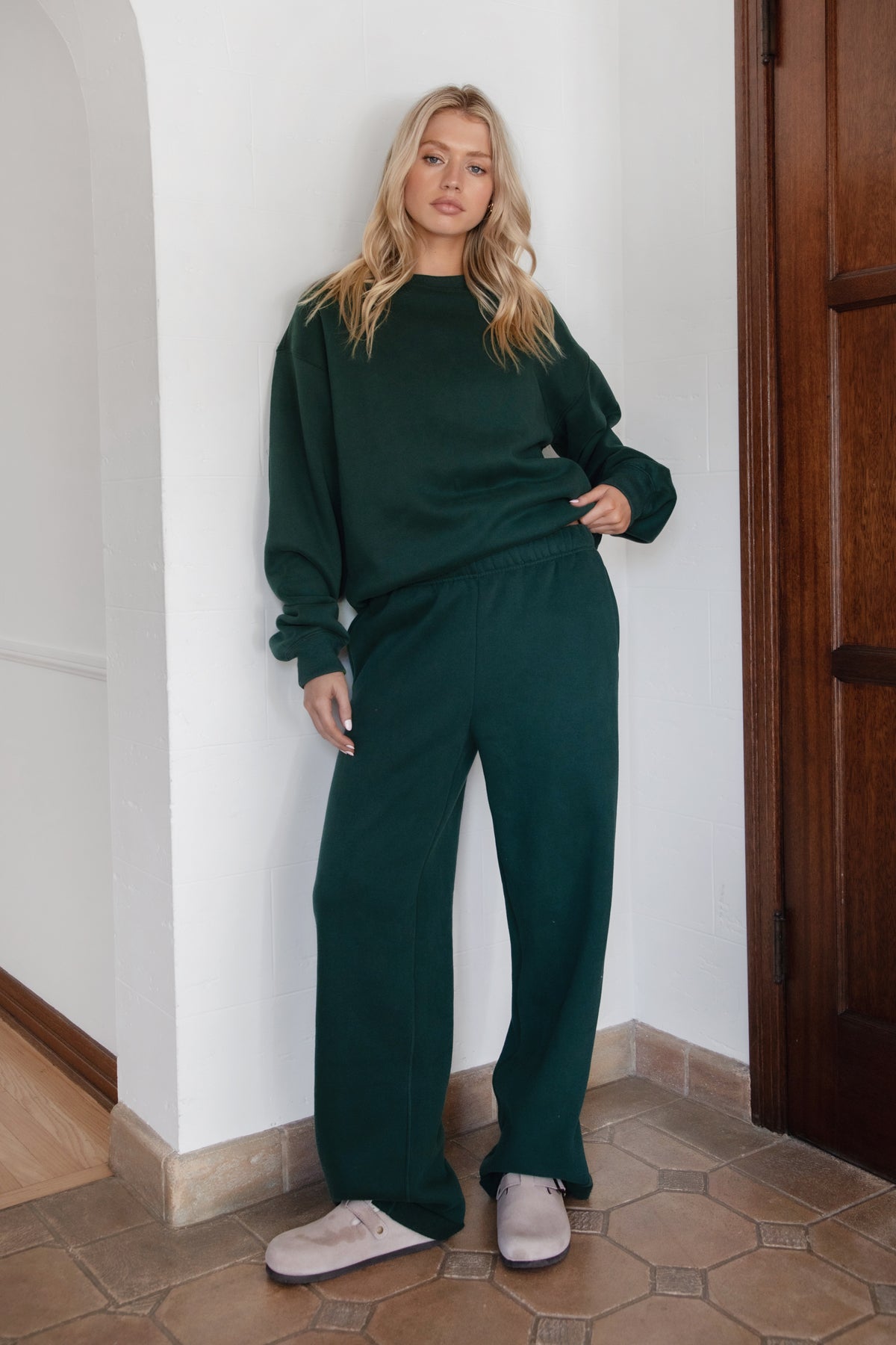 Woman wearing the TIC TOC TJ31656 LANI forrest green cloud fleece crew neck pullover sweatshirt featuring dropped shoulders, ribbed trim, and cozy fleece fabric with the matching bottoms
