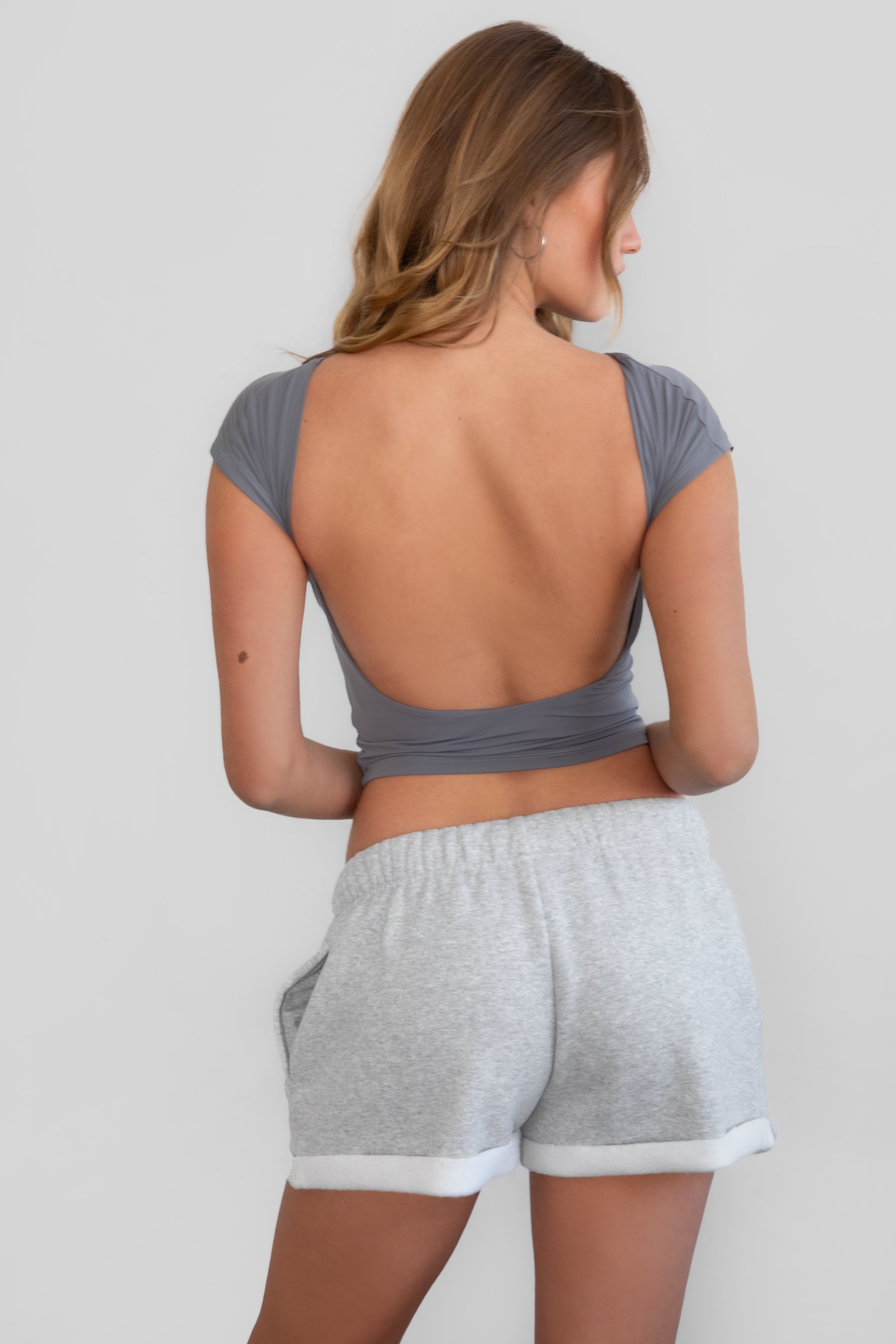 TIC TOC KENDALL Open Back Short Sleeve Baby Tee in charcoal featuring low back detail and silky spandex fabric.