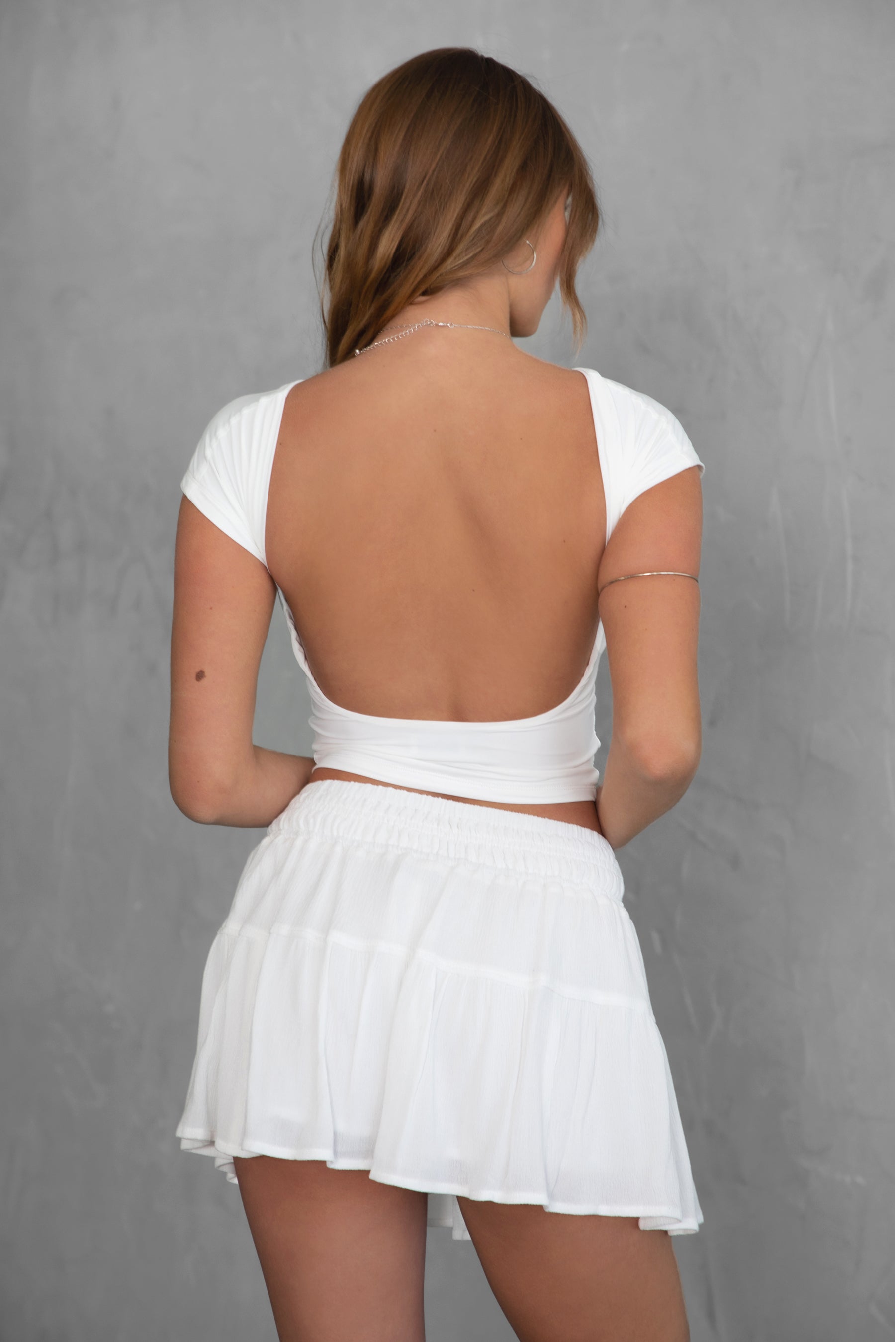 TIC TOC KENDALL Open Back Short Sleeve Baby Tee in White featuring low back detail and silky spandex fabric.