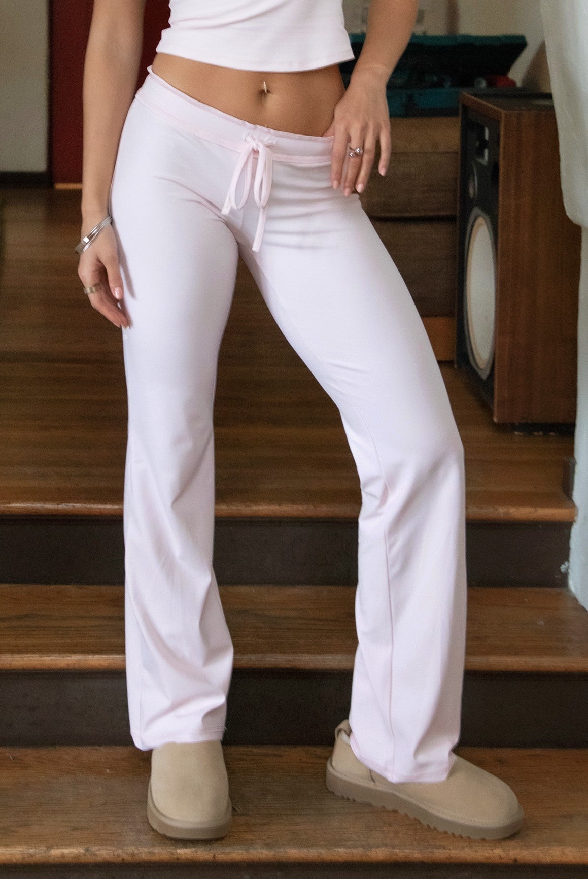 Woman wearing TIC TOC PH31905BA-NYLEE-WL navy NYLEE WL wide leg pants made from soft span jersey fabric, featuring a high-stretch body-hugging fit through the hips, foldover waistband with tie detail, and full-length wide leg silhouette, styled indoors with a matching top for a coordinated lounge/athleisure look.