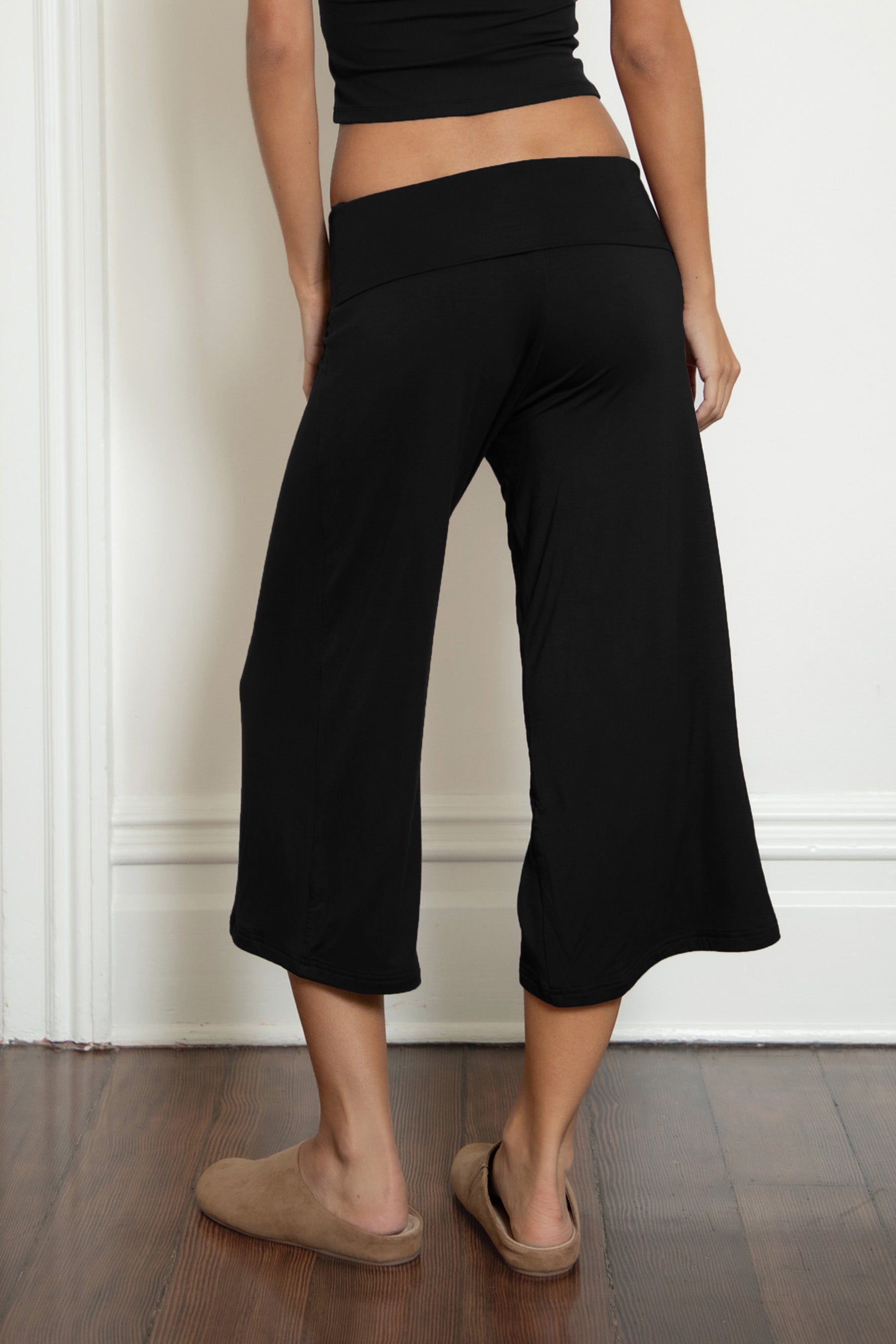 Woman wearing TIC TOC PH32000 SORA rayon spandex fold over low rise wide leg leggings featuring a soft lightweight jersey fabric, fold-over waistband, relaxed wide leg silhouette, and capri length, styled for a clean laid-back lounge and everyday look.
