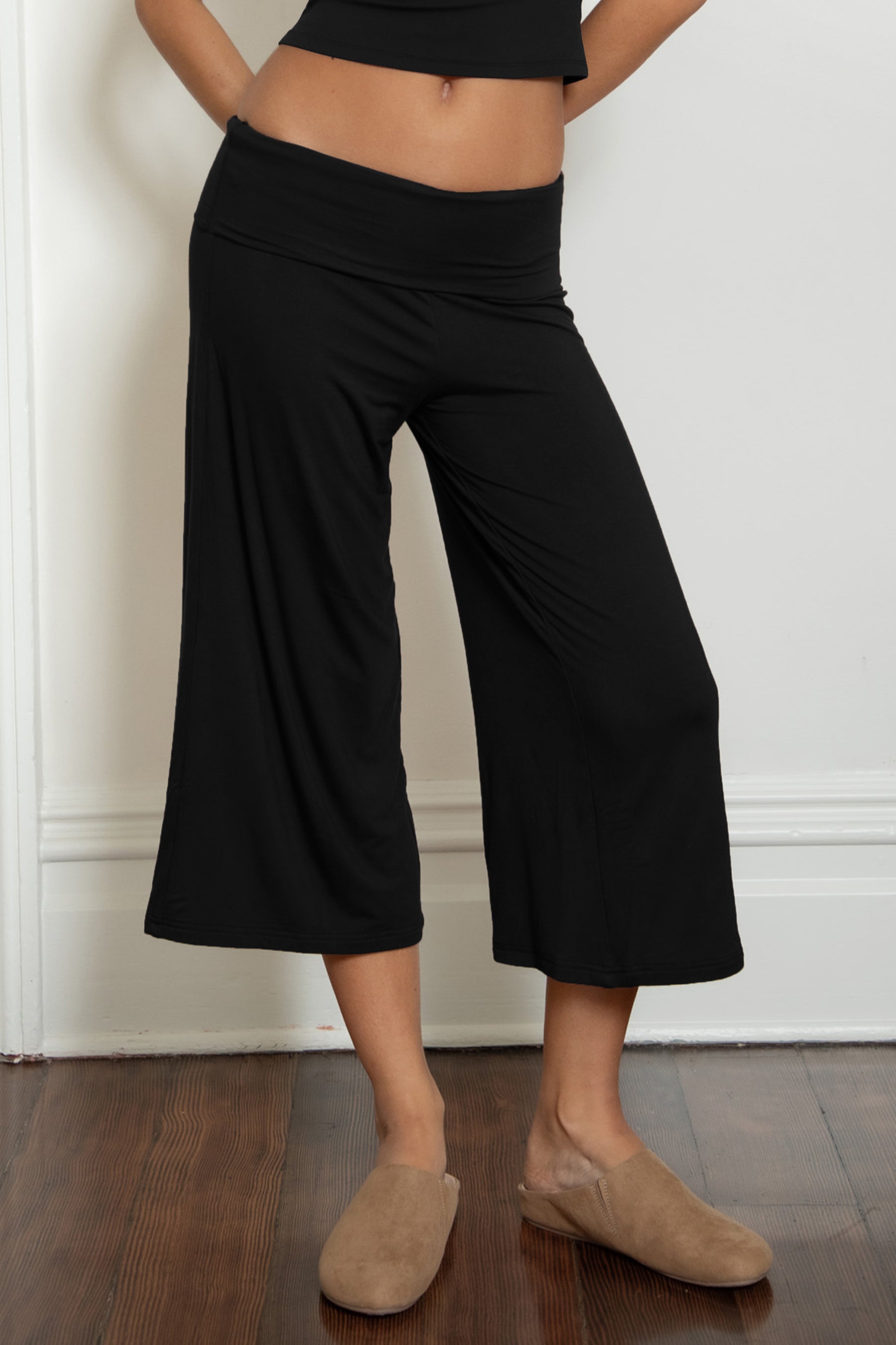 Woman wearing TIC TOC PH32000 SORA rayon spandex fold over low rise wide leg leggings featuring a soft lightweight jersey fabric, fold-over waistband, relaxed wide leg silhouette, and capri length, styled for a clean laid-back lounge and everyday look.