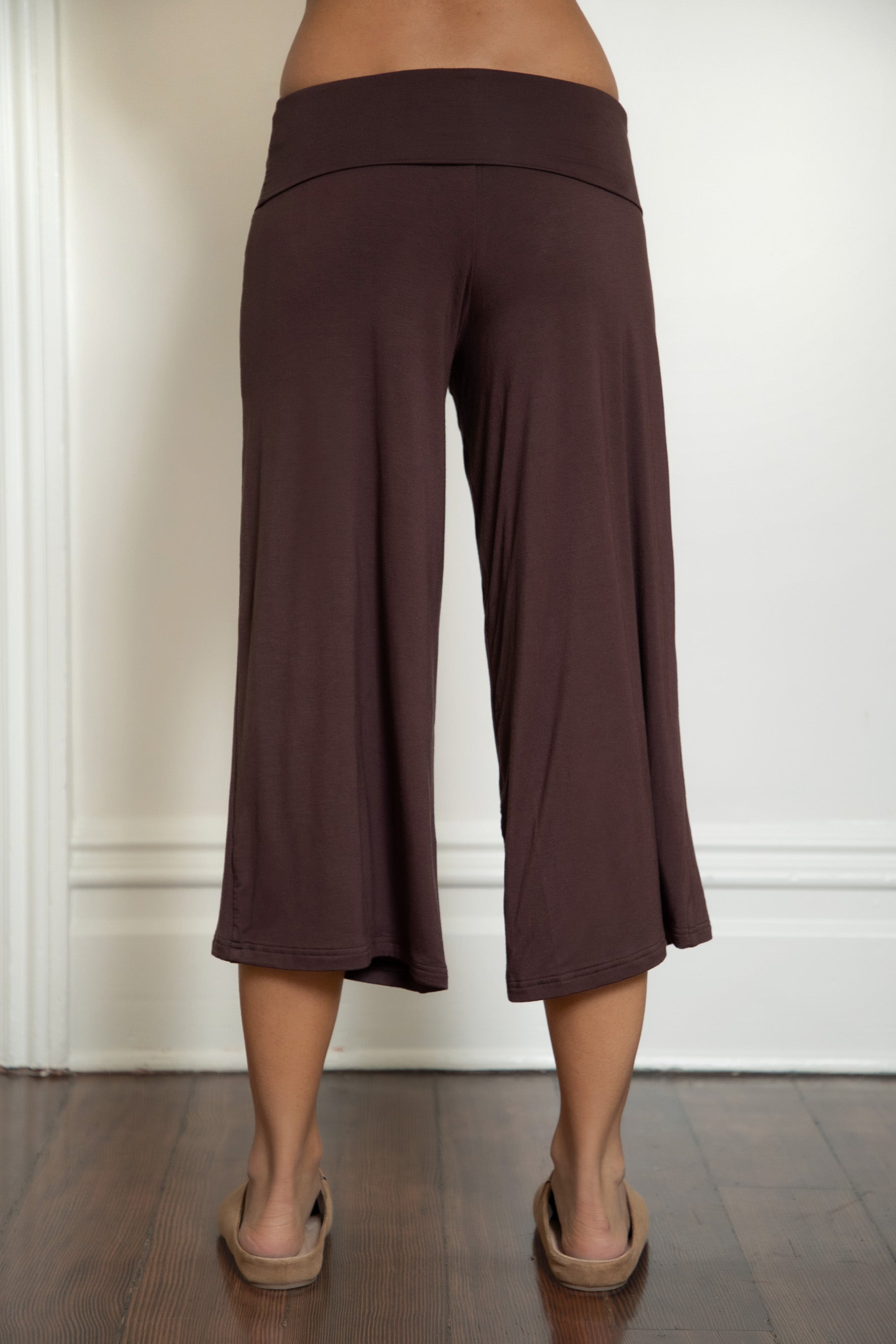 Woman wearing TIC TOC PH32000 SORA rayon spandex fold over low rise wide leg leggings featuring a soft lightweight jersey fabric, fold-over waistband, relaxed wide leg silhouette, and capri length, styled for a clean laid-back lounge and everyday look.