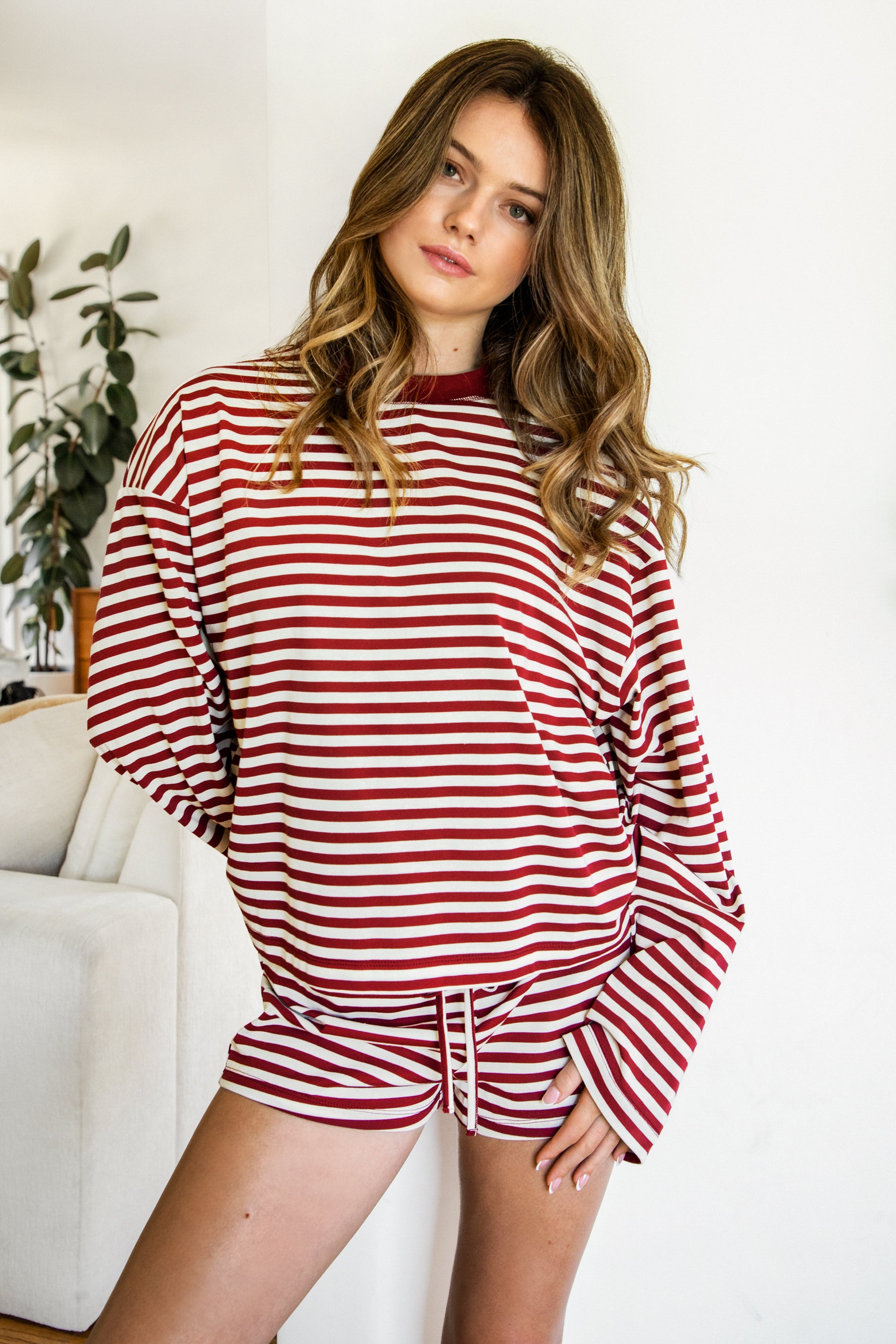Woman wearing MARLOWE stripe mid waist drawstring stretch shorts featuring an allover stripe pattern, adjustable drawstring waistband, micro shorts length, relaxed easy fit silhouette, and soft stretch jersey fabric for cozy casual lounge styling.