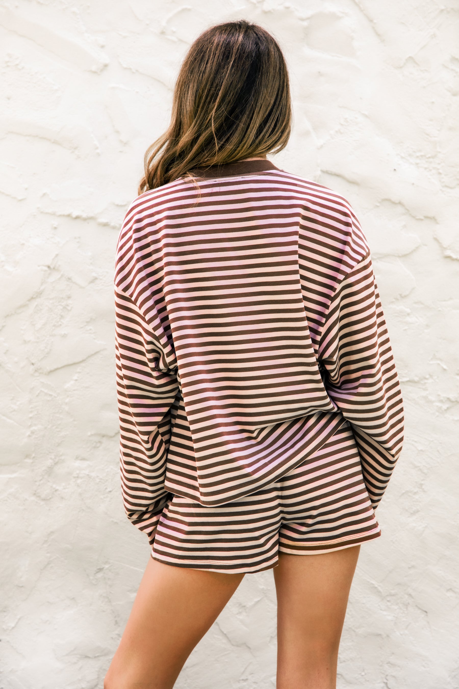 Woman wearing MARLOWE stripe mid waist drawstring stretch shorts featuring an allover stripe pattern, adjustable drawstring waistband, micro shorts length, relaxed easy fit silhouette, and soft stretch jersey fabric for cozy casual lounge styling.