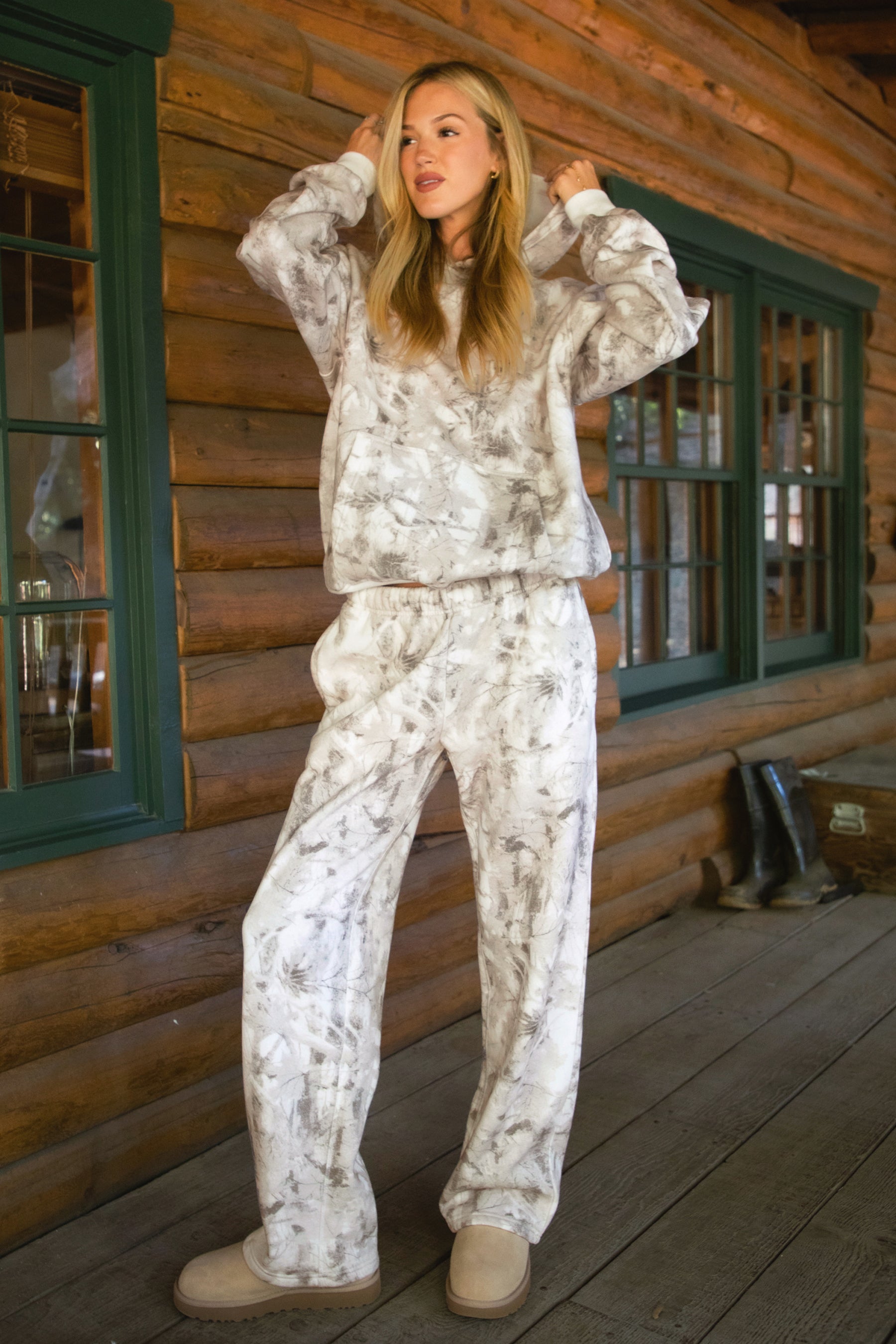 Women wearing TIC TOC AVERY Woodland Camo Wide Leg Sweatpants with elastic waistband, drawcord, in a soft Cloud Fleece fabric in a cabin
