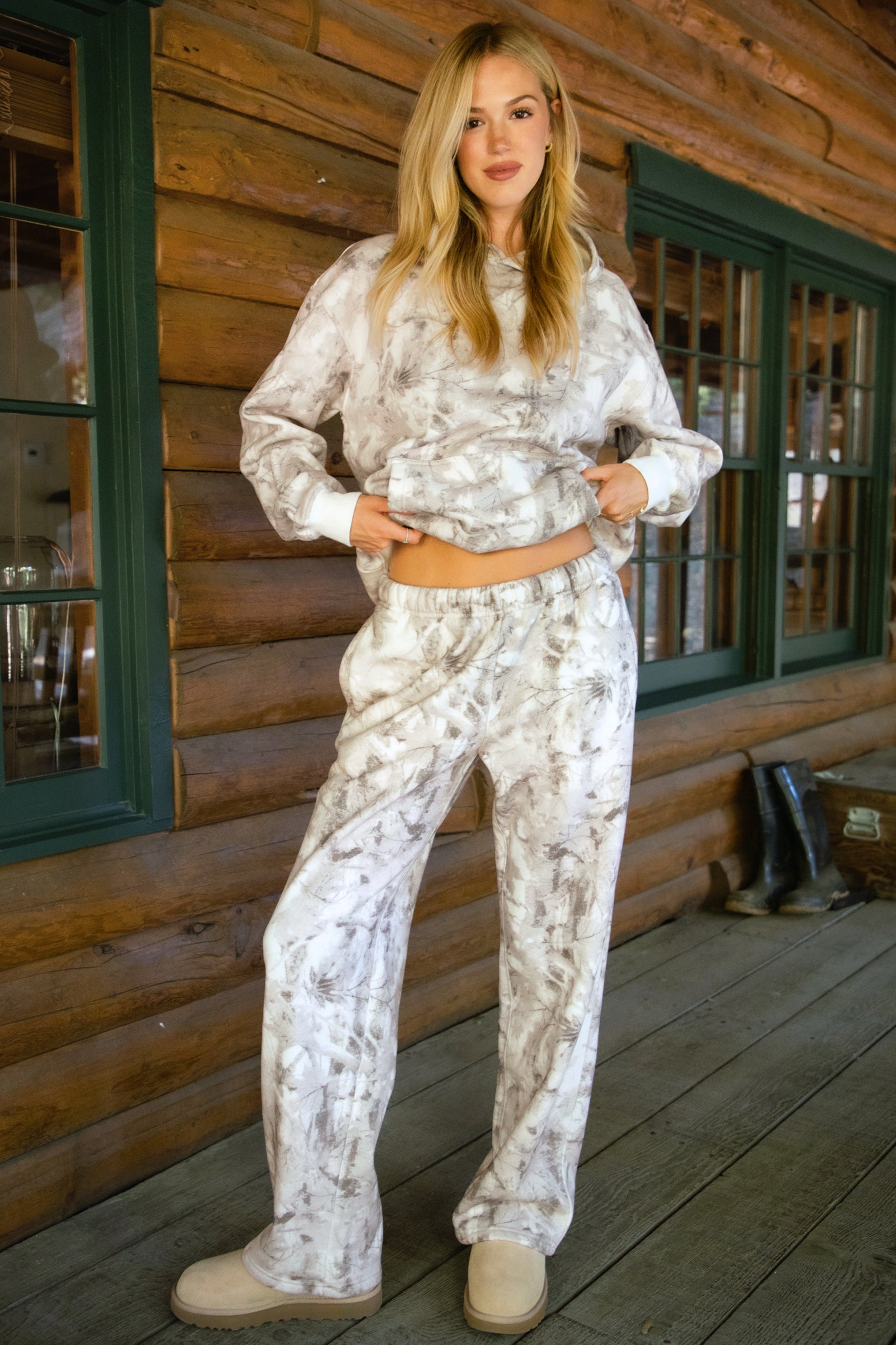 Women wearing TIC TOC AVERY Woodland Camo Wide Leg Sweatpants with elastic waistband, drawcord, in a soft Cloud Fleece fabric in a cabin