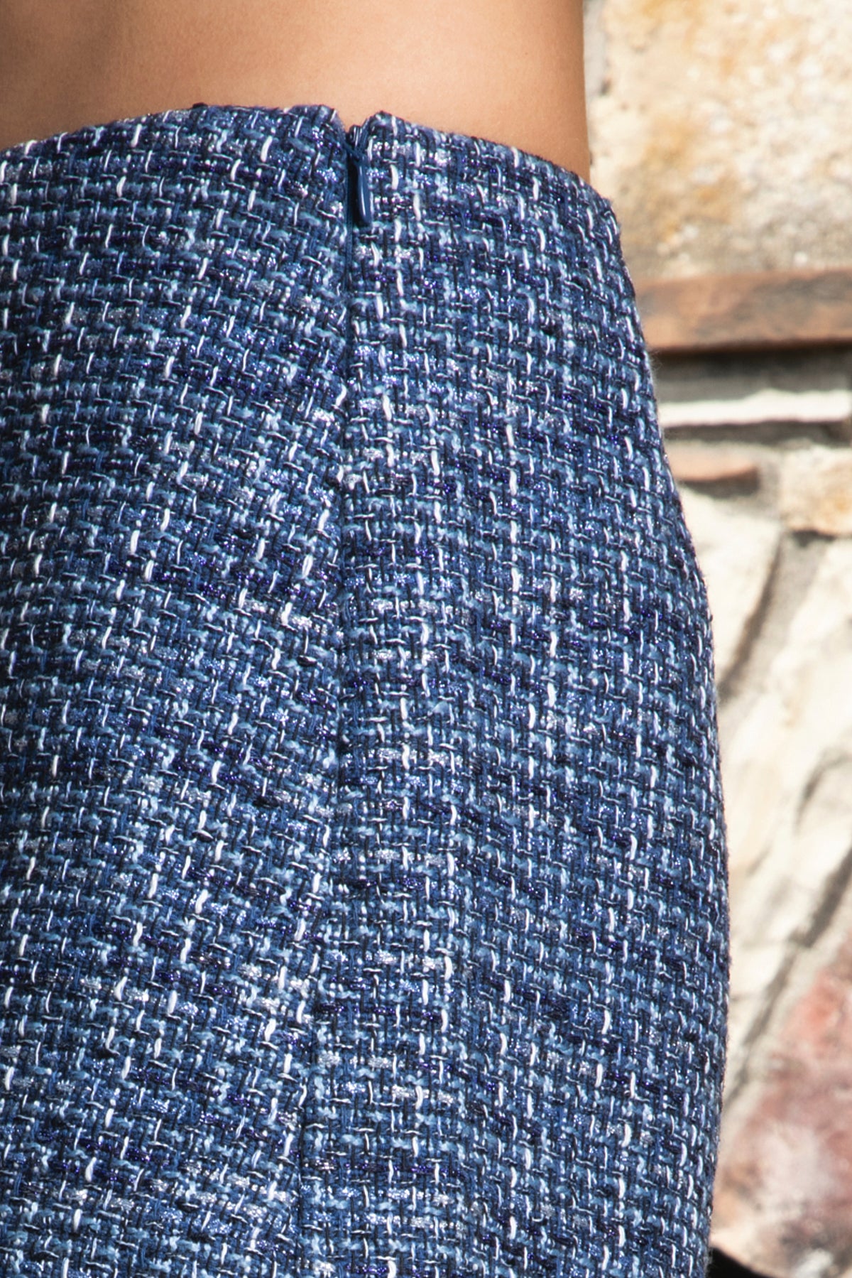 Woman wearing COCO navy blue lurex tweed skort featuring shimmering textured tweed fabric, subtle metallic lurex detail, mini length, skirt inspired front with hidden shorts comfort, clean fitted waist, side zipper closure, and fully lined construction for going out and holiday styling.