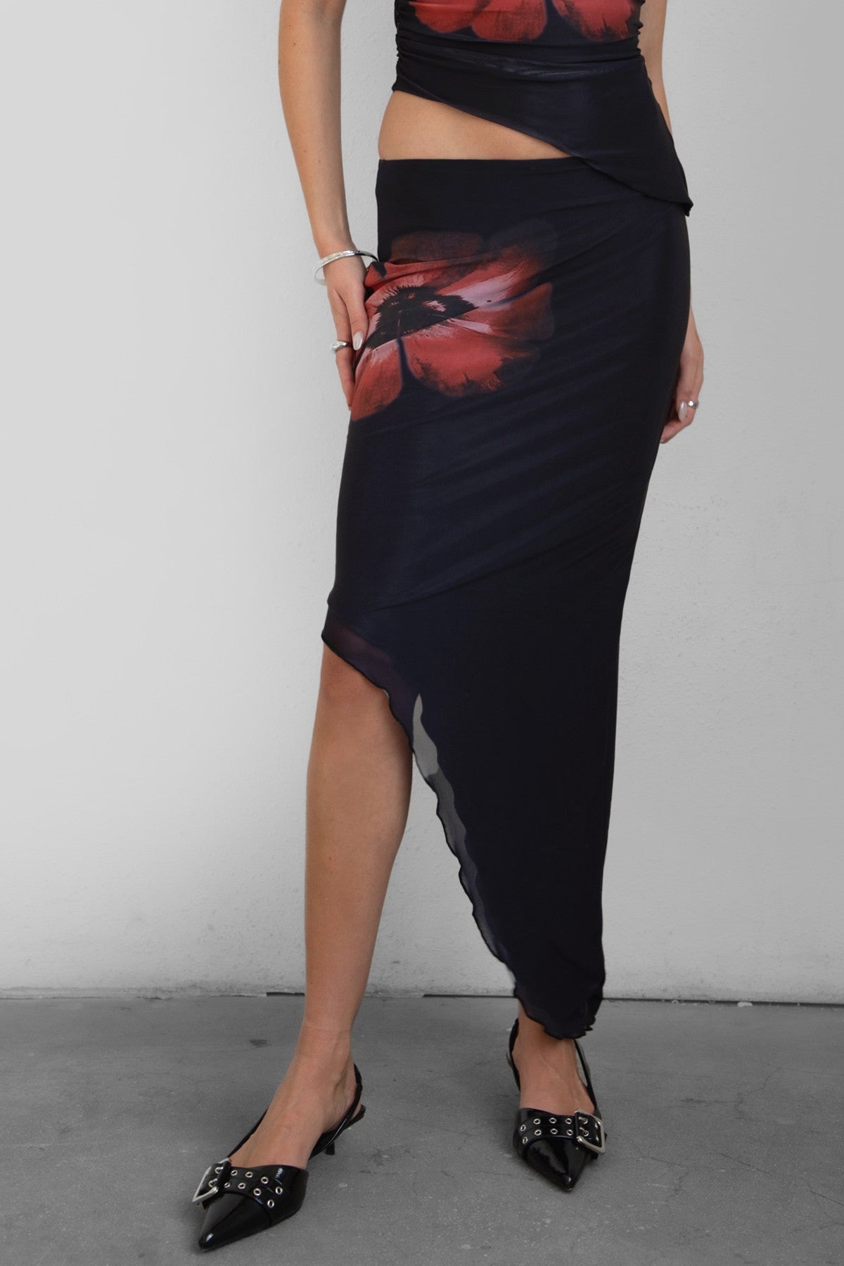 TIC TOC MUAH S Mesh Print Asymmetrical Skirt in Black and red with mid rise stretch waistband and angled hem.