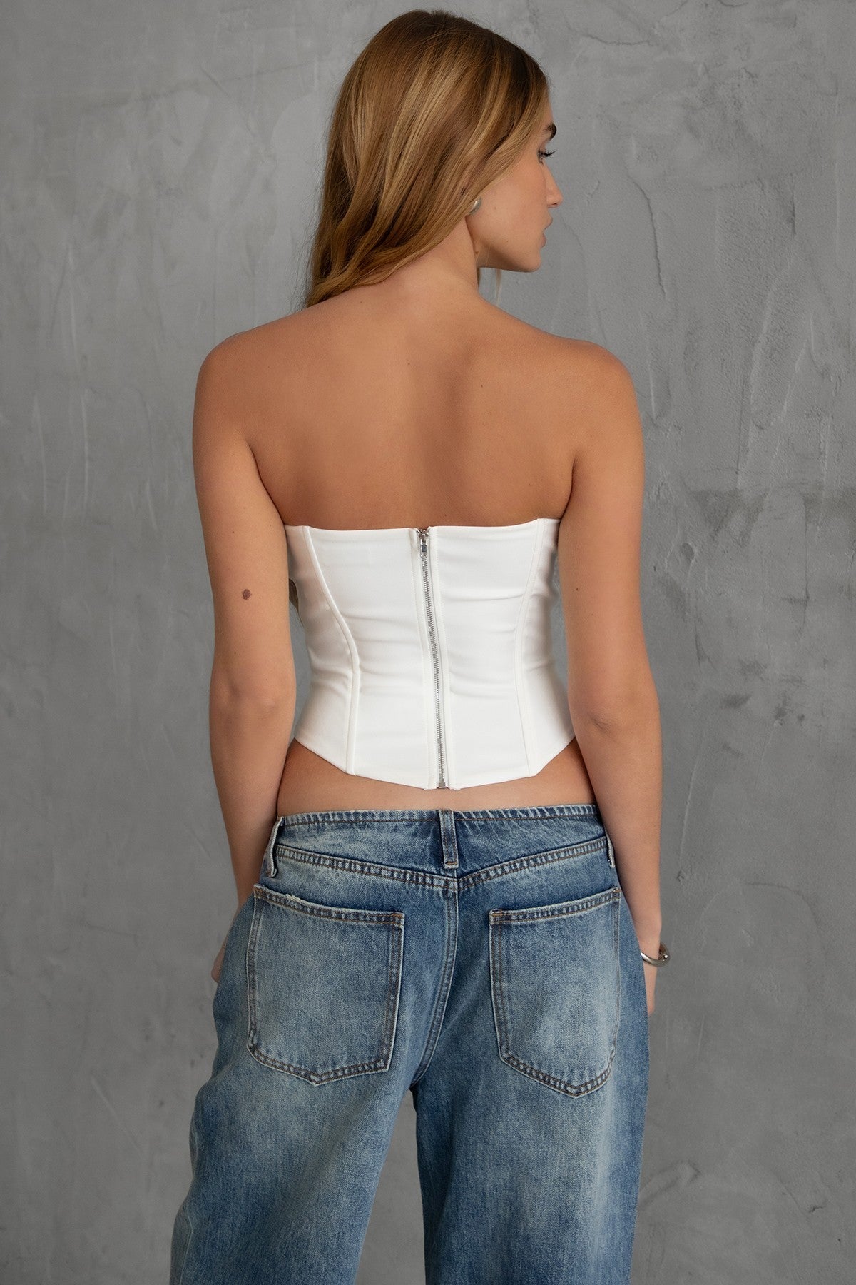 TIC TOC KARMEN Strapless Corset Top in white with sheer front cutout, rhinestone bows, and curved hem.