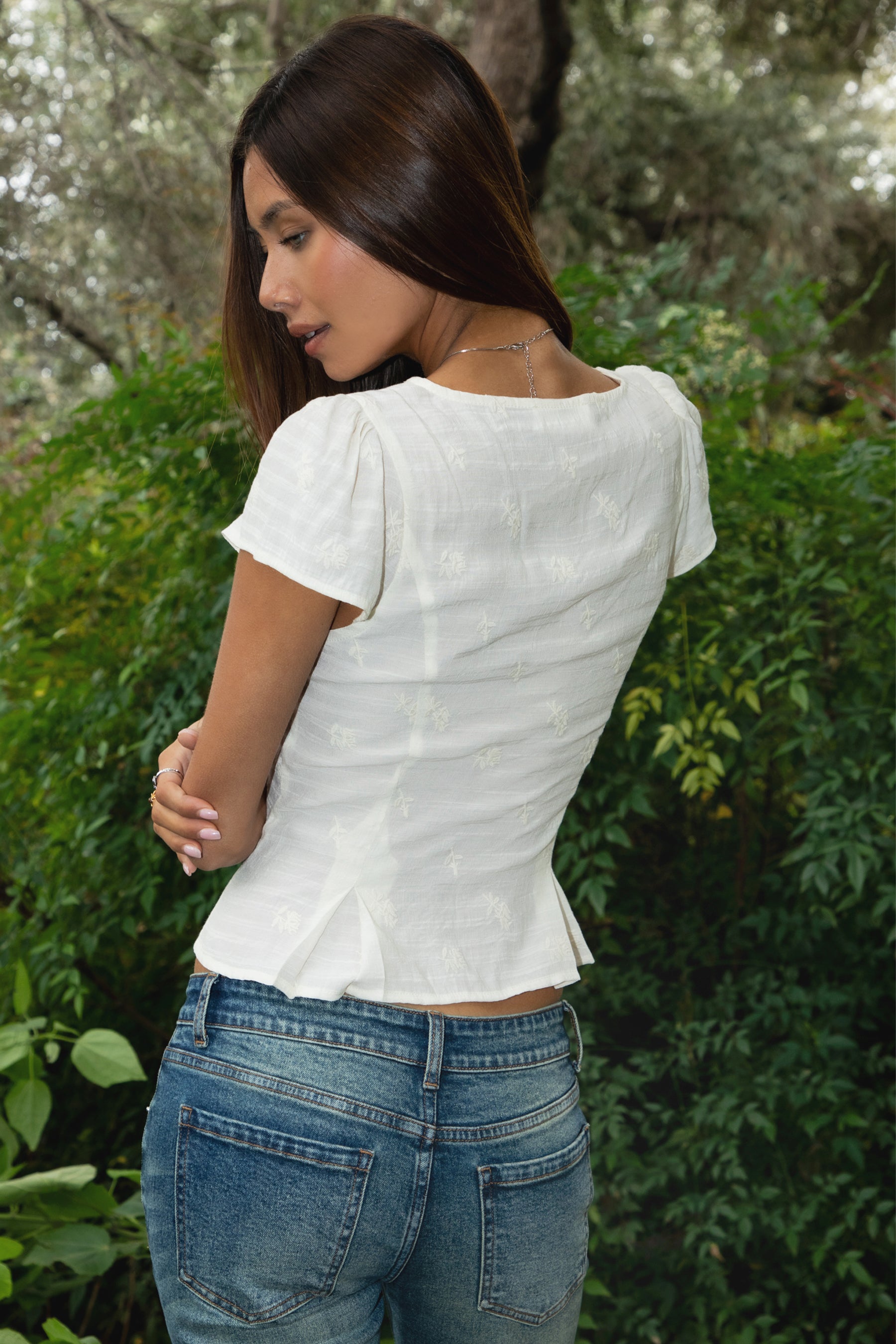 Woman wearing TIC TOC TA32052 SERENITY embroidered lace trim short sleeve blouse featuring soft gauze fabric with delicate floral embroidery, a cropped feminine fitted shape, V neckline with lace trim, front button closure with subtle keyhole opening, and lightweight short sleeves for a romantic western-inspired summer look.