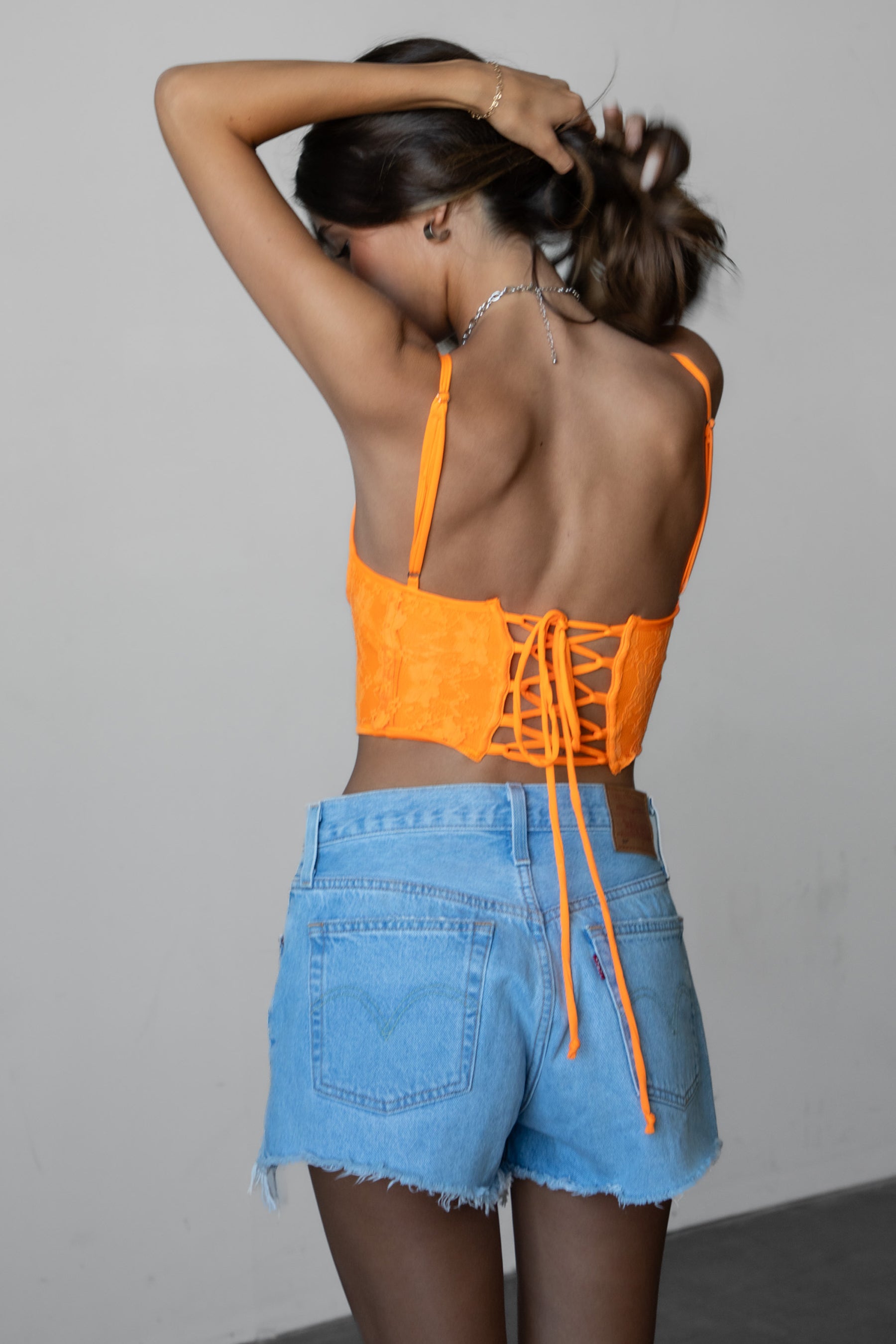 TIC TOC BAYLOR Lace Bustier Top in orange with sweetheart neckline, lace-up back, and boned curved hem design.