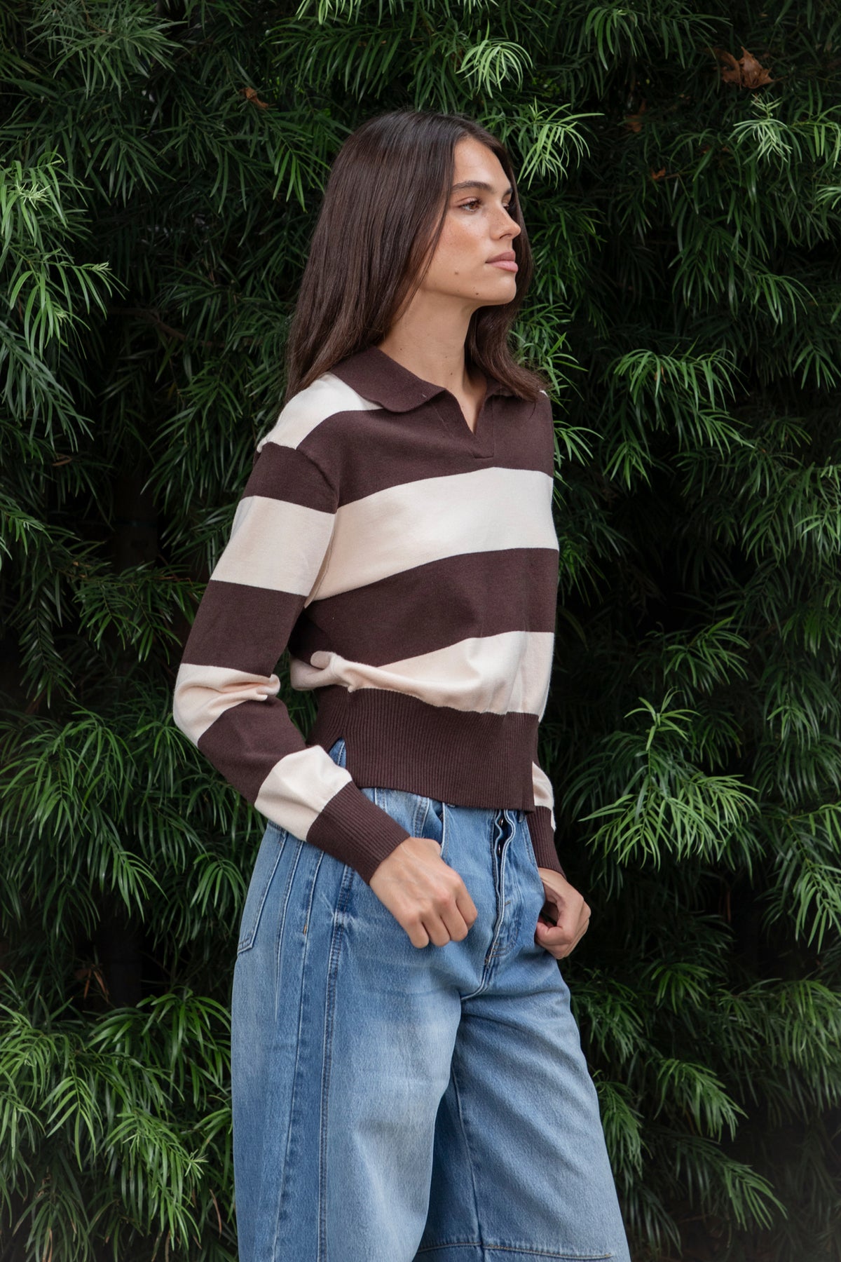 Woman wearing PRESCOTT striped collared classic preppy sweater featuring soft sweater knit fabric, bold contrast stripes, polo inspired collar with open V neckline, wide horizontal stripe design, relaxed dropped shoulder silhouette, long sleeves with contrast ribbed cuffs, ribbed hem, and subtle side slits.