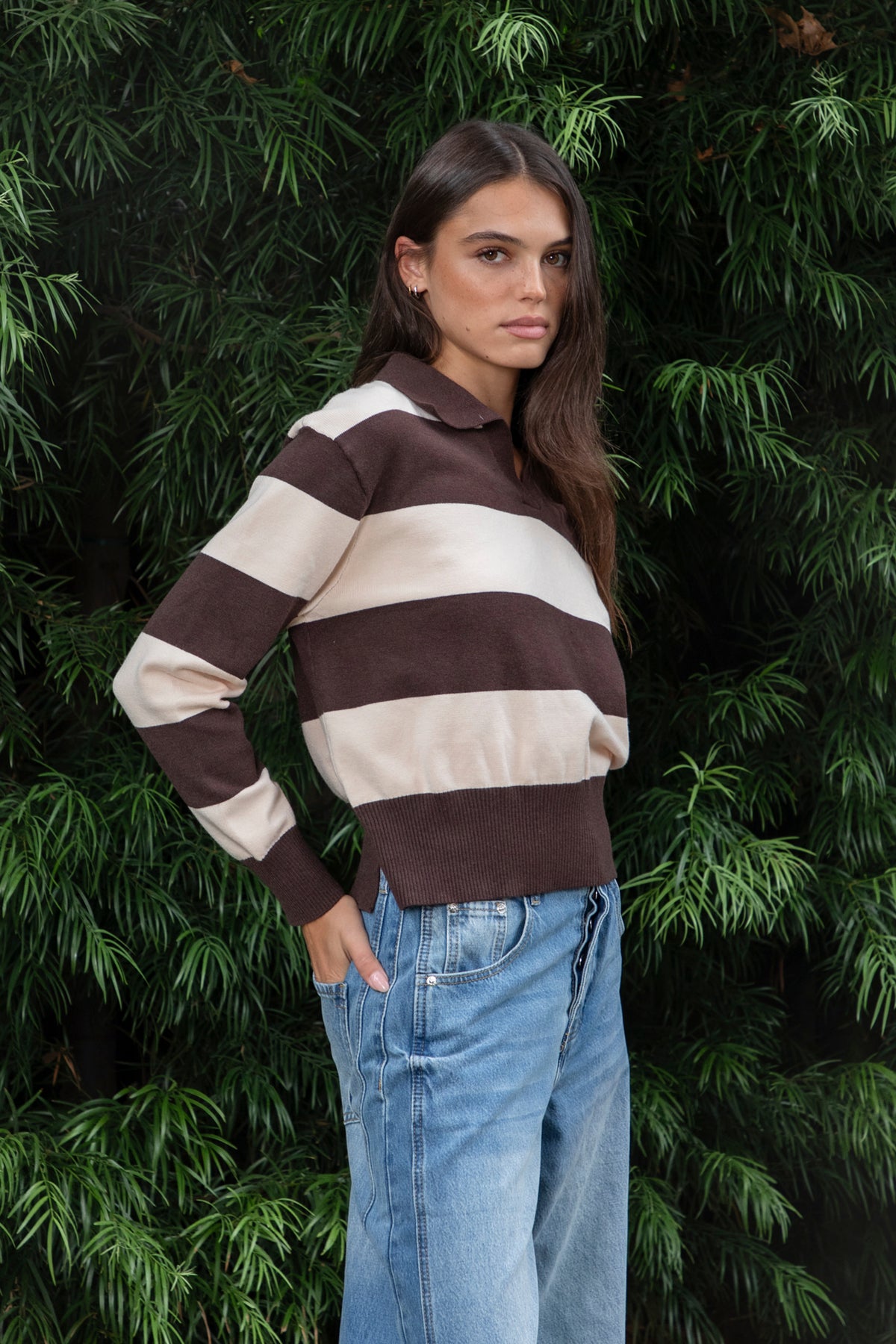 Woman wearing PRESCOTT striped collared classic preppy sweater featuring soft sweater knit fabric, bold contrast stripes, polo inspired collar with open V neckline, wide horizontal stripe design, relaxed dropped shoulder silhouette, long sleeves with contrast ribbed cuffs, ribbed hem, and subtle side slits.