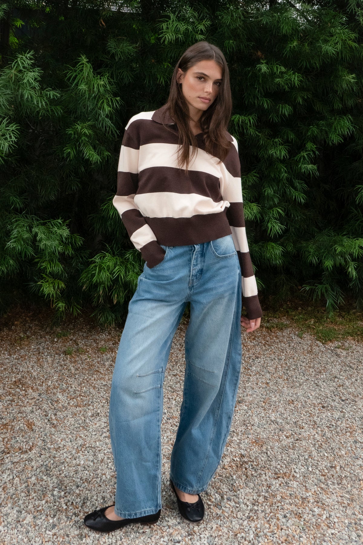 Woman wearing PRESCOTT striped collared classic preppy sweater featuring soft sweater knit fabric, bold contrast stripes, polo inspired collar with open V neckline, wide horizontal stripe design, relaxed dropped shoulder silhouette, long sleeves with contrast ribbed cuffs, ribbed hem, and subtle side slits.