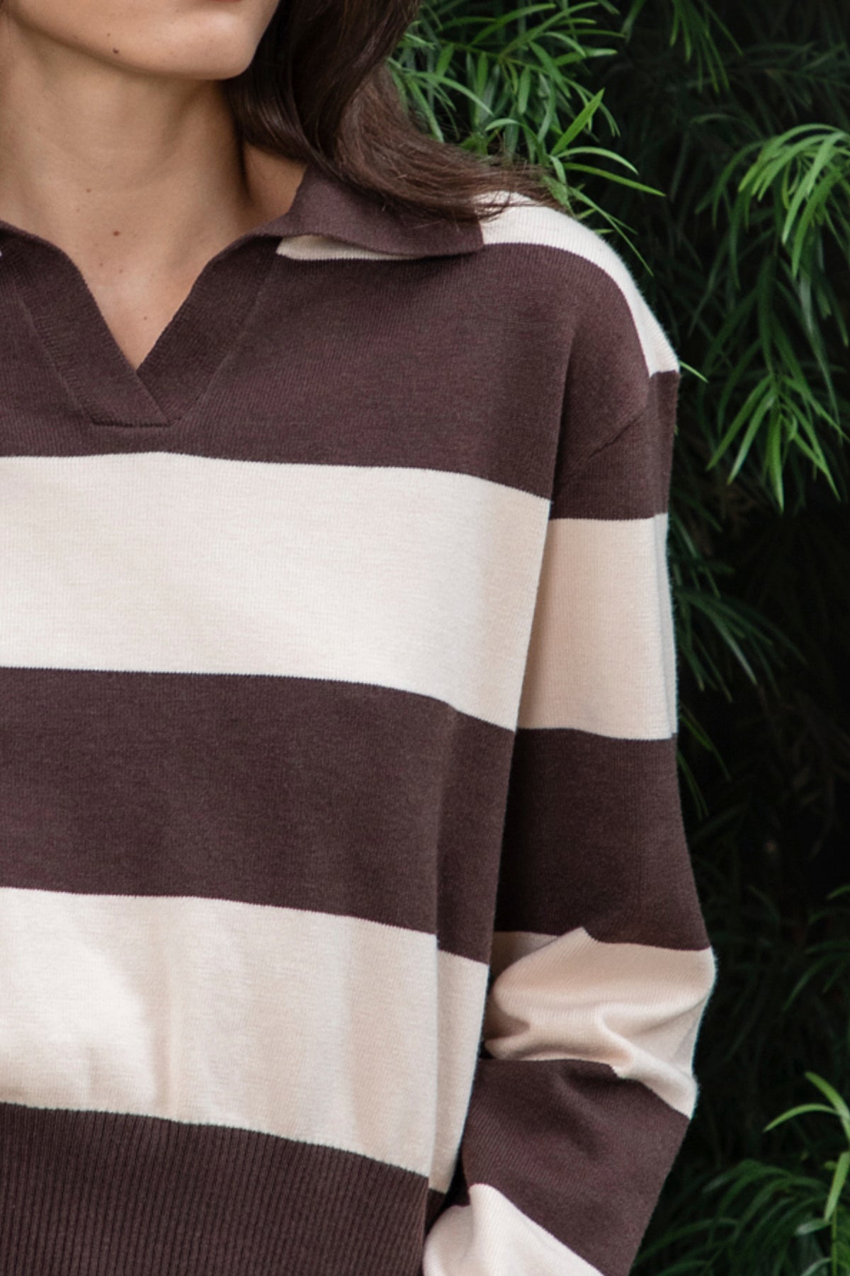 Woman wearing PRESCOTT striped collared classic preppy sweater featuring soft sweater knit fabric, bold contrast stripes, polo inspired collar with open V neckline, wide horizontal stripe design, relaxed dropped shoulder silhouette, long sleeves with contrast ribbed cuffs, ribbed hem, and subtle side slits.
