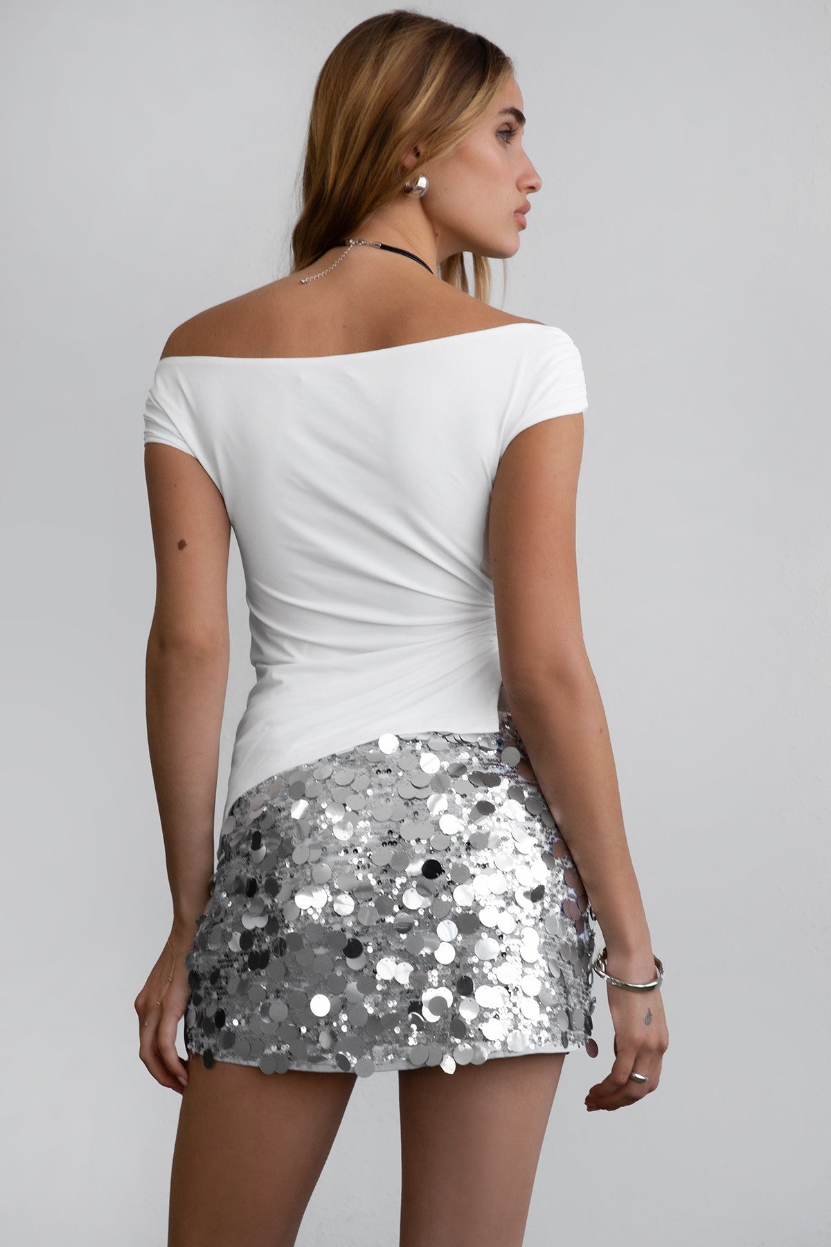 TIC TOC INEZ Off The Shoulder Top in white with asymmetrical hem, side slit, and silver ring detail in sleek spandex fabric.
