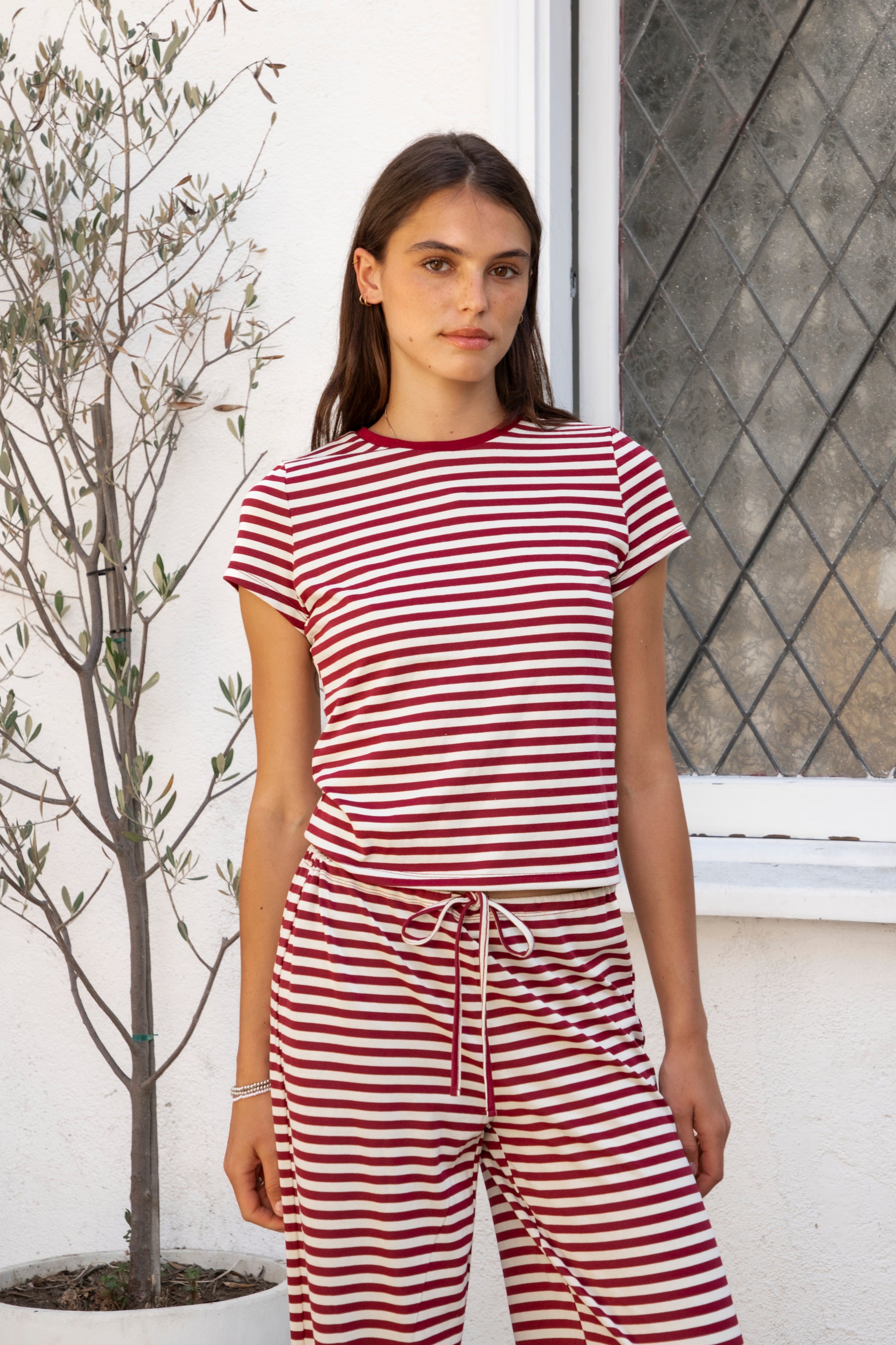 Woman wearing MARLOWE classic crewneck stripe short sleeve t-shirt featuring soft cotton blend fabric, lightweight comfortable feel, timeless striped pattern, classic crew neckline, short sleeves, relaxed slim fit, and effortless essential design for layering or everyday styling.