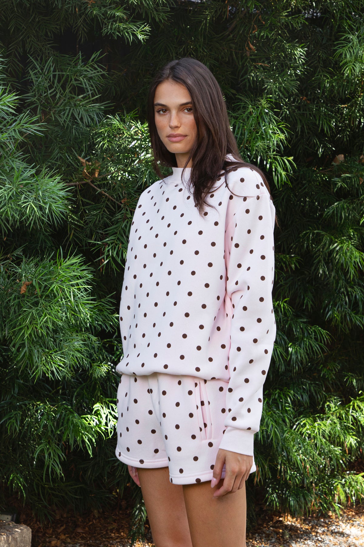 Woman wearing PIPPA polka dot plush fleece mock neck sweatshirt featuring soft cotton blend fleece fabric, allover polka dot print, classic crew neckline with ribbed trim, relaxed silhouette, long sleeves with dropped shoulders, ribbed cuffs and hem, and cozy construction designed to pair with the matching PIPPA shorts.