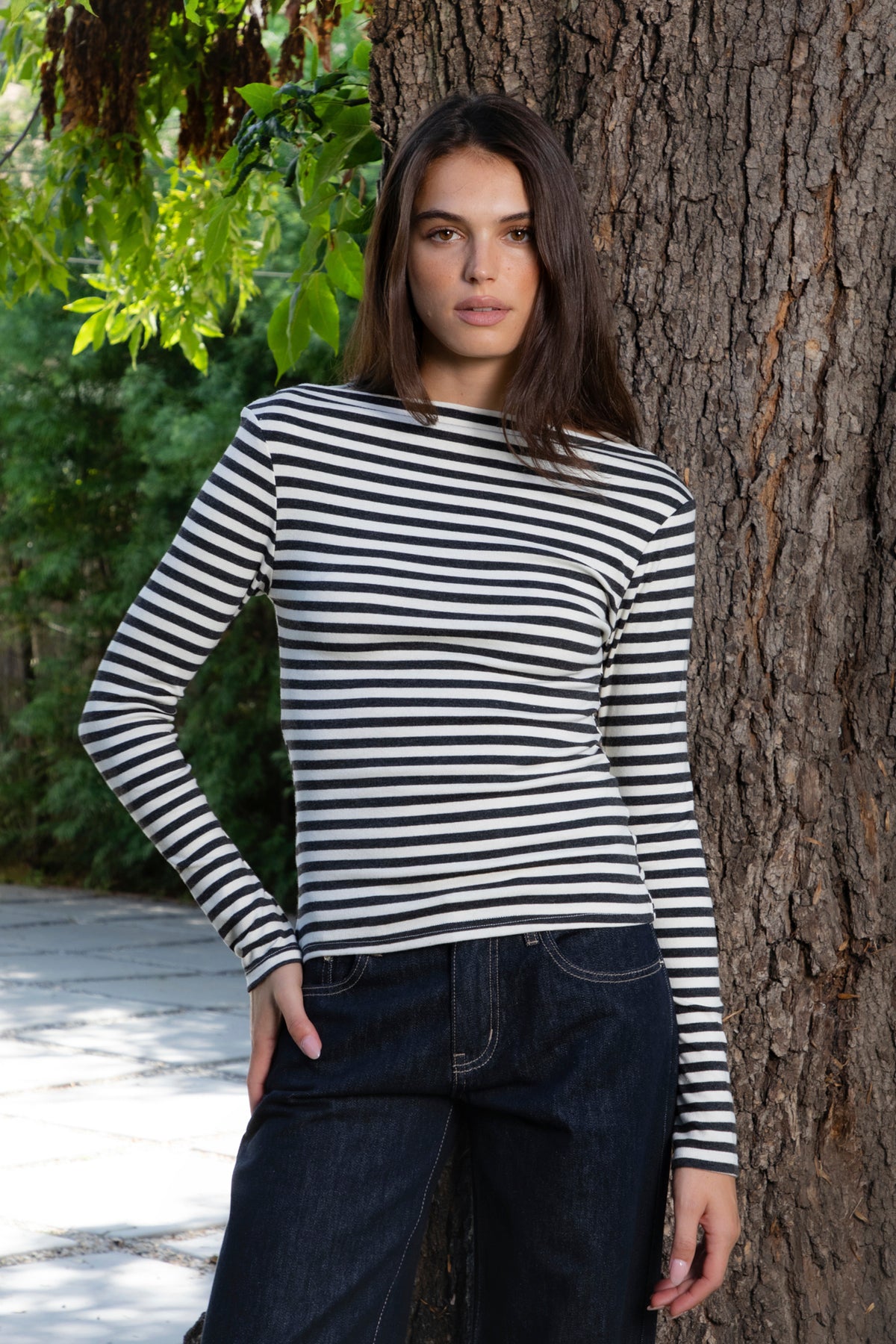 Woman wearing ROSLYN striped boat neck long sleeve top featuring soft brushed cotton stretch jersey fabric, classic horizontal stripe pattern, wide boat neckline that can be styled on or slightly off the shoulder, fitted silhouette, slim full length sleeves, and hip length hem for easy everyday styling.