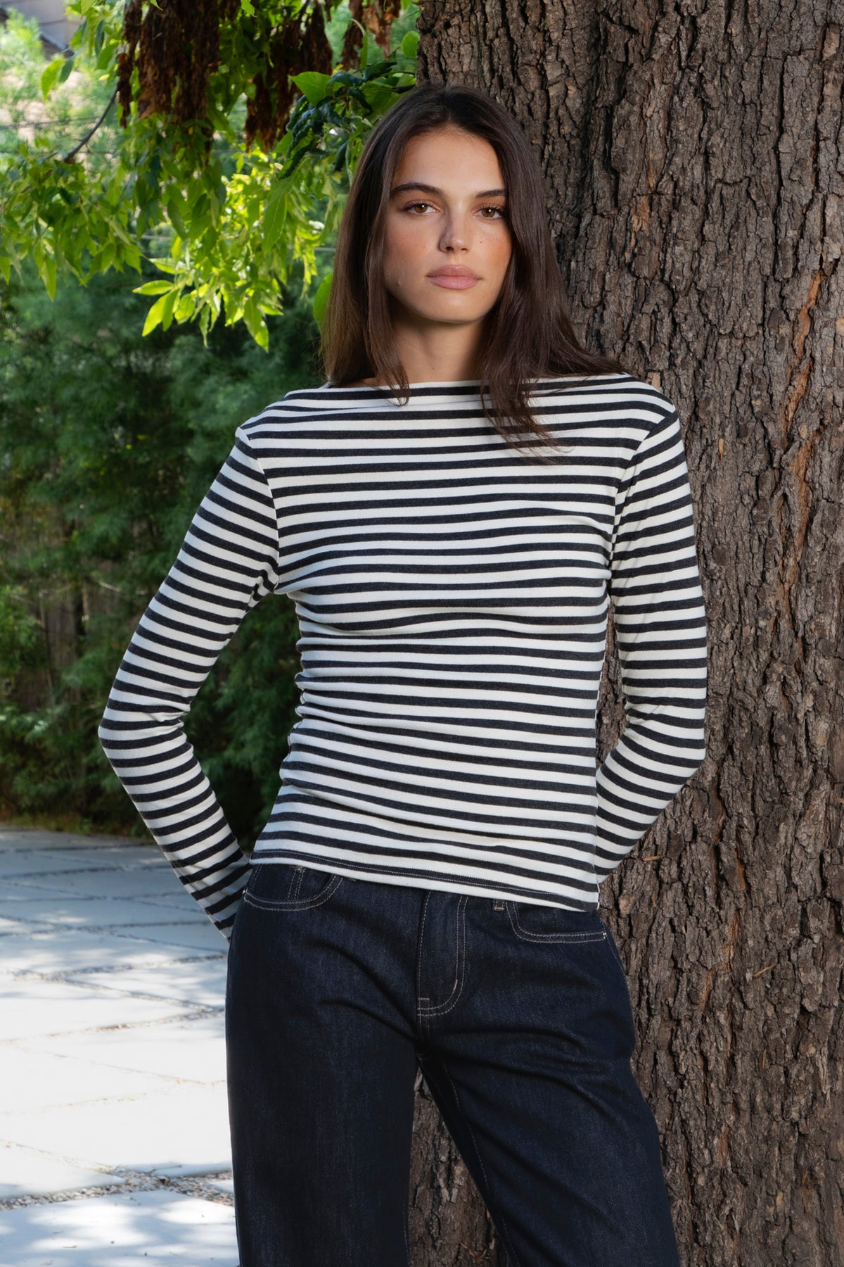 Woman wearing ROSLYN striped boat neck long sleeve top featuring soft brushed cotton stretch jersey fabric, classic horizontal stripe pattern, wide boat neckline that can be styled on or slightly off the shoulder, fitted silhouette, slim full length sleeves, and hip length hem for easy everyday styling.