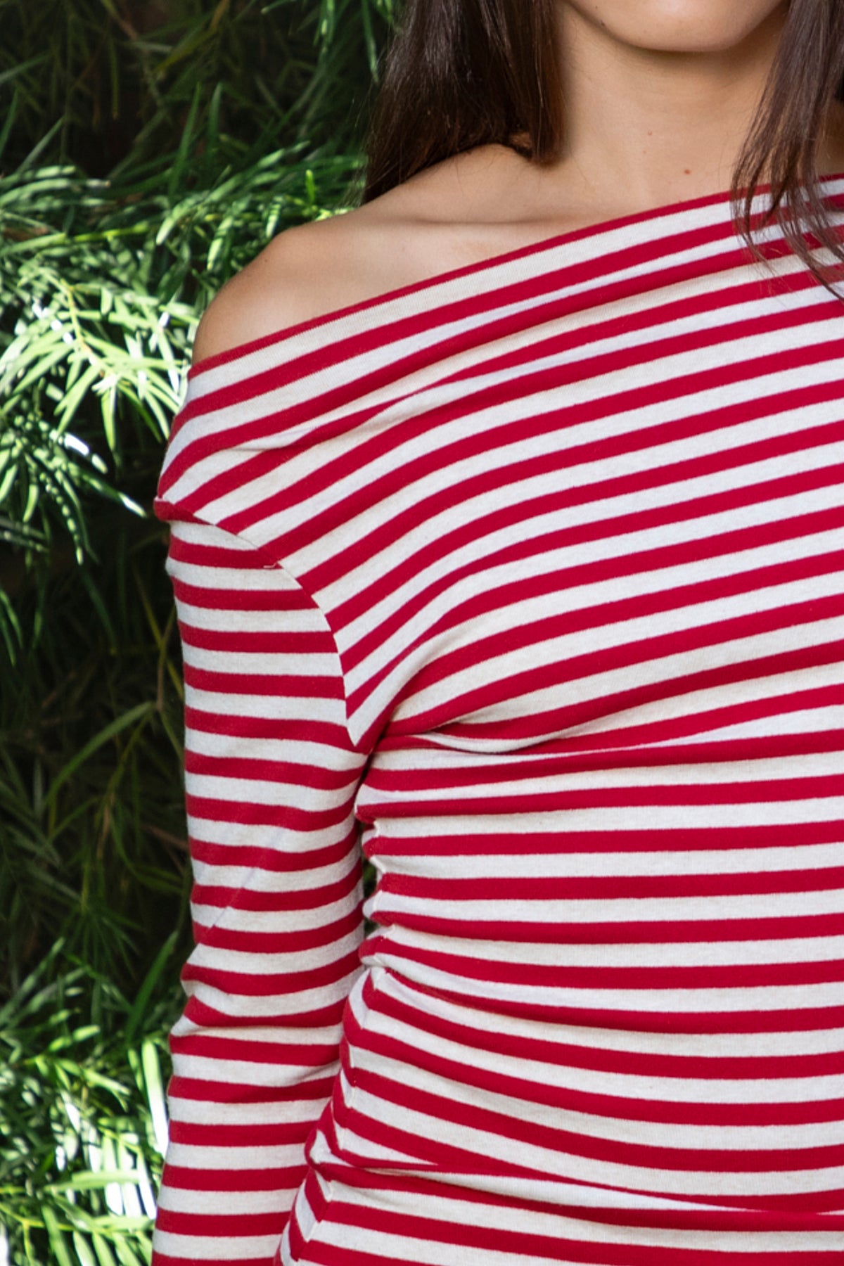 Woman wearing ROSLYN striped boat neck long sleeve top featuring soft brushed cotton stretch jersey fabric, classic horizontal stripe pattern, wide boat neckline that can be styled on or slightly off the shoulder, fitted silhouette, slim full length sleeves, and hip length hem for easy everyday styling.