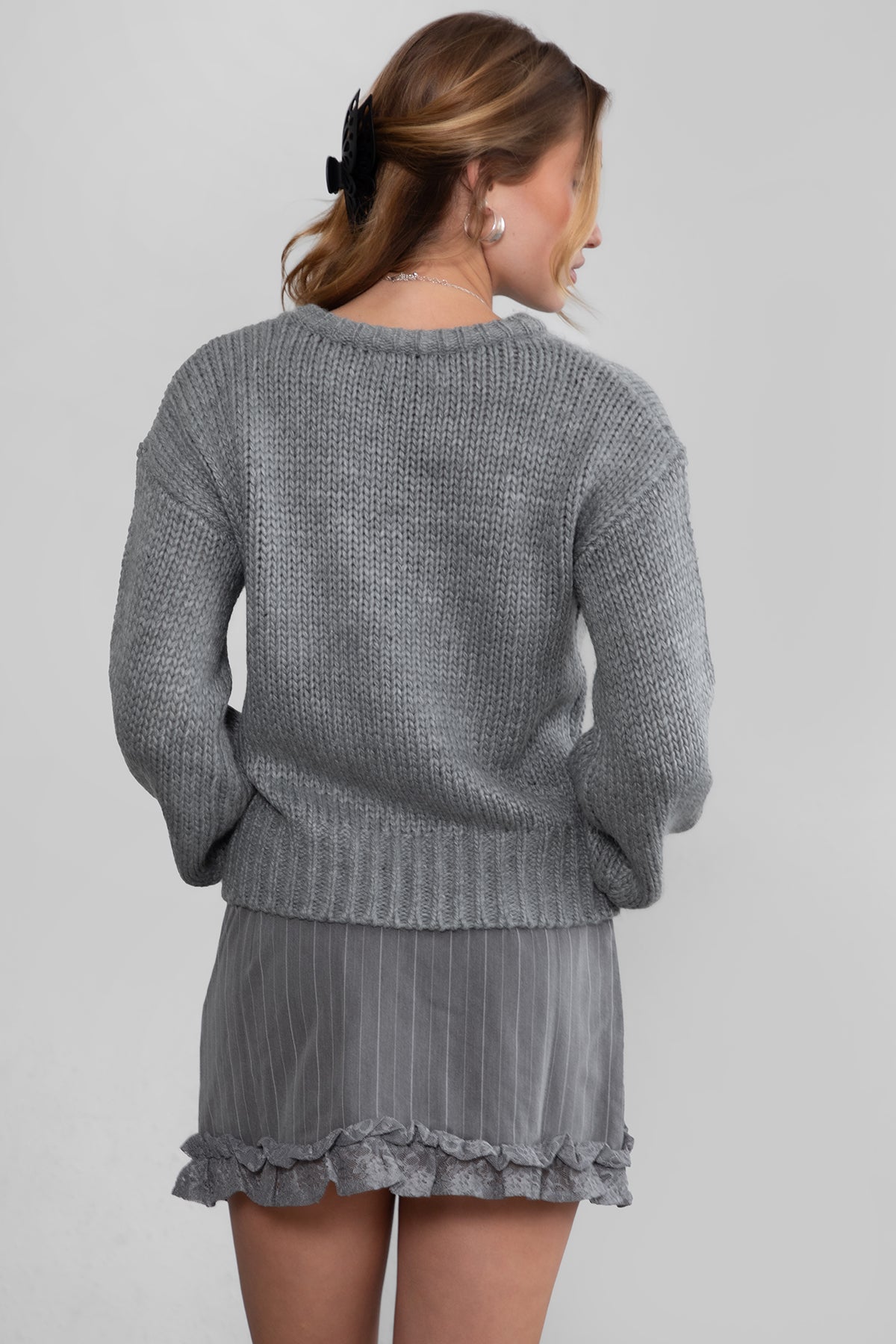 Model wearing TIC TOC KELLY Ribbed Knit Sweater in grey Styled fall outfit with striped mini skirt.