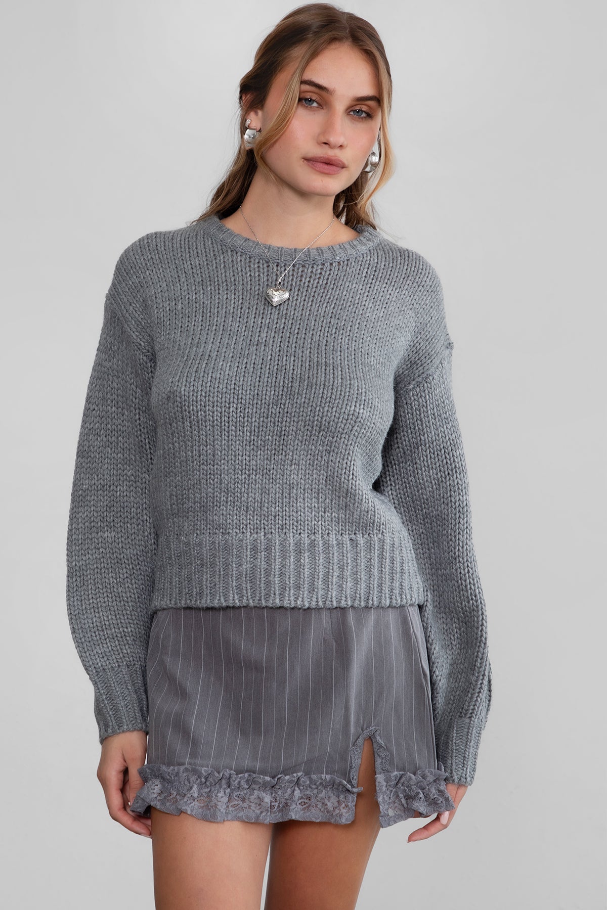 Model wearing TIC TOC KELLY Ribbed Knit Sweater in grey Styled fall outfit with striped mini skirt.