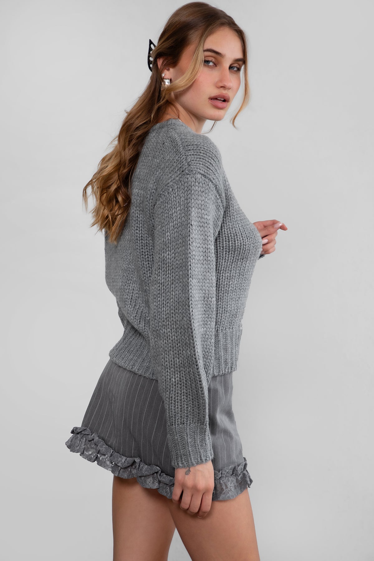 Model wearing TIC TOC KELLY Ribbed Knit Sweater in grey Styled fall outfit with striped mini skirt.