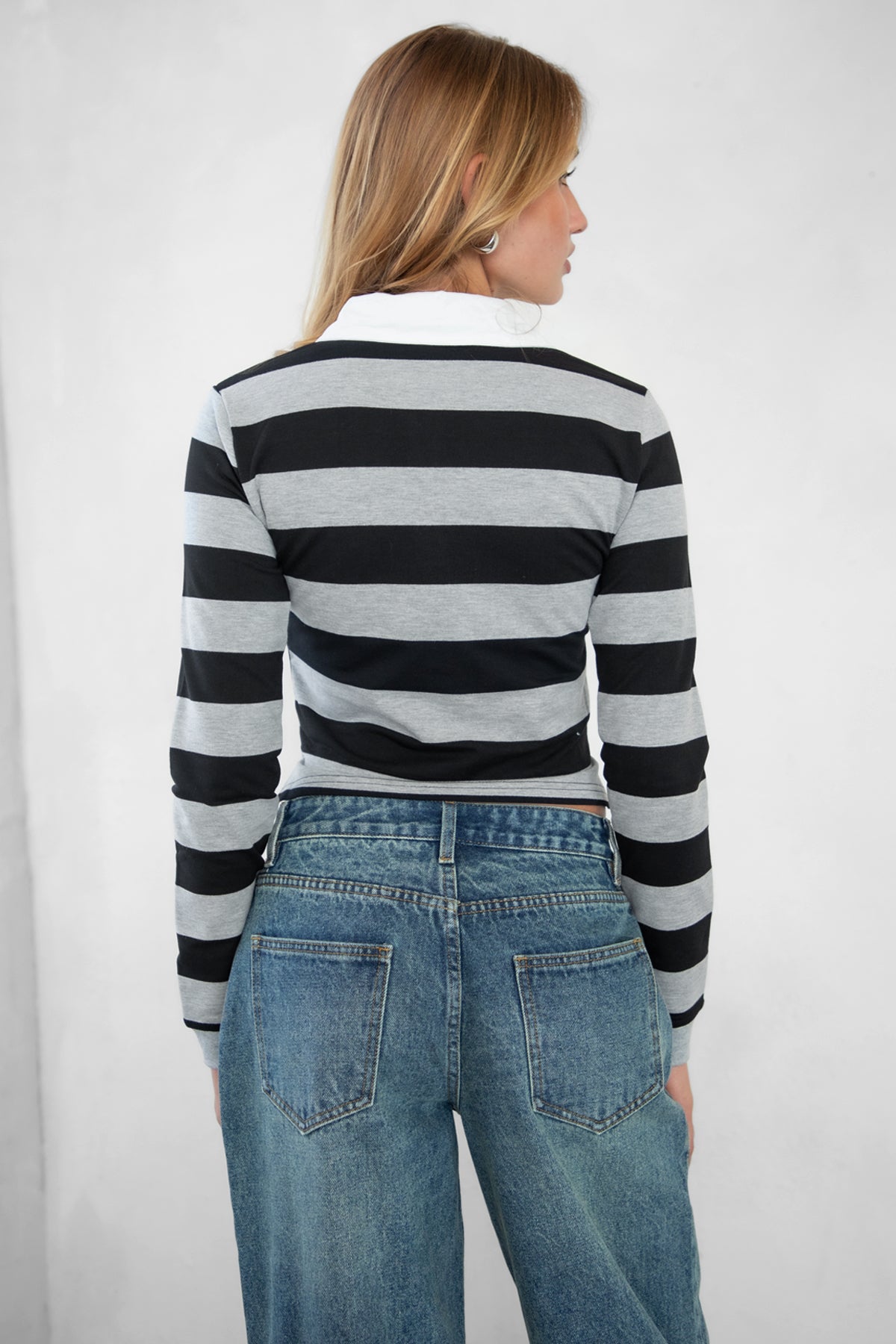 Woman wearing TIC TOC TOMMY Rugby Striped Long Sleeve Shirt in grey black with denim jeans, showing the back detail
