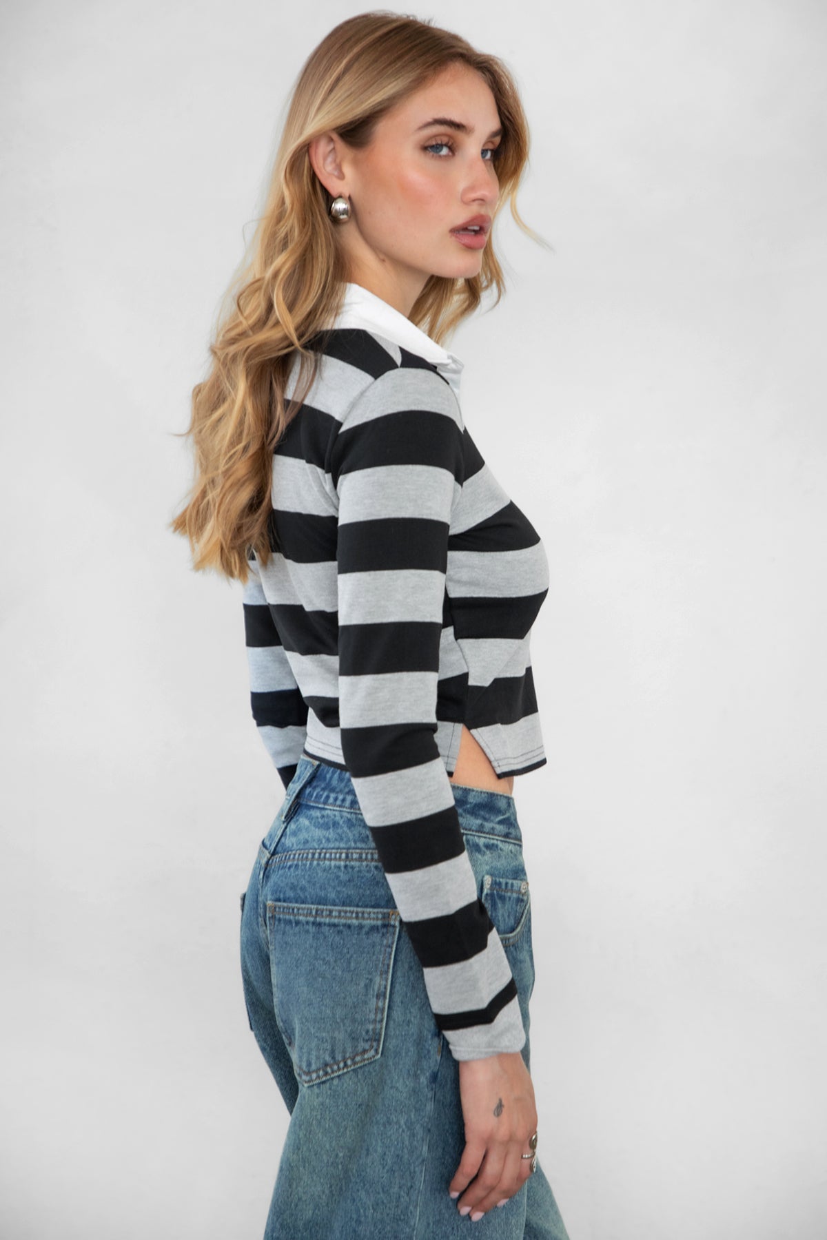 Woman wearing TIC TOC TOMMY Rugby Striped Long Sleeve Shirt in grey black with denim jeans, showing the side detail