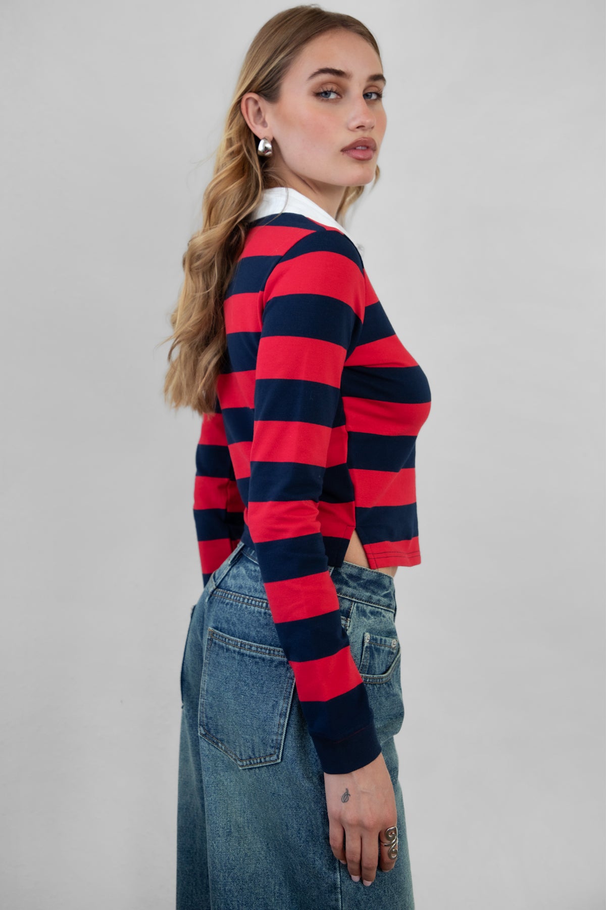 Woman wearing TIC TOC TOMMY Rugby Striped Long Sleeve Shirt in red navy with denim jeans, showing the side detail