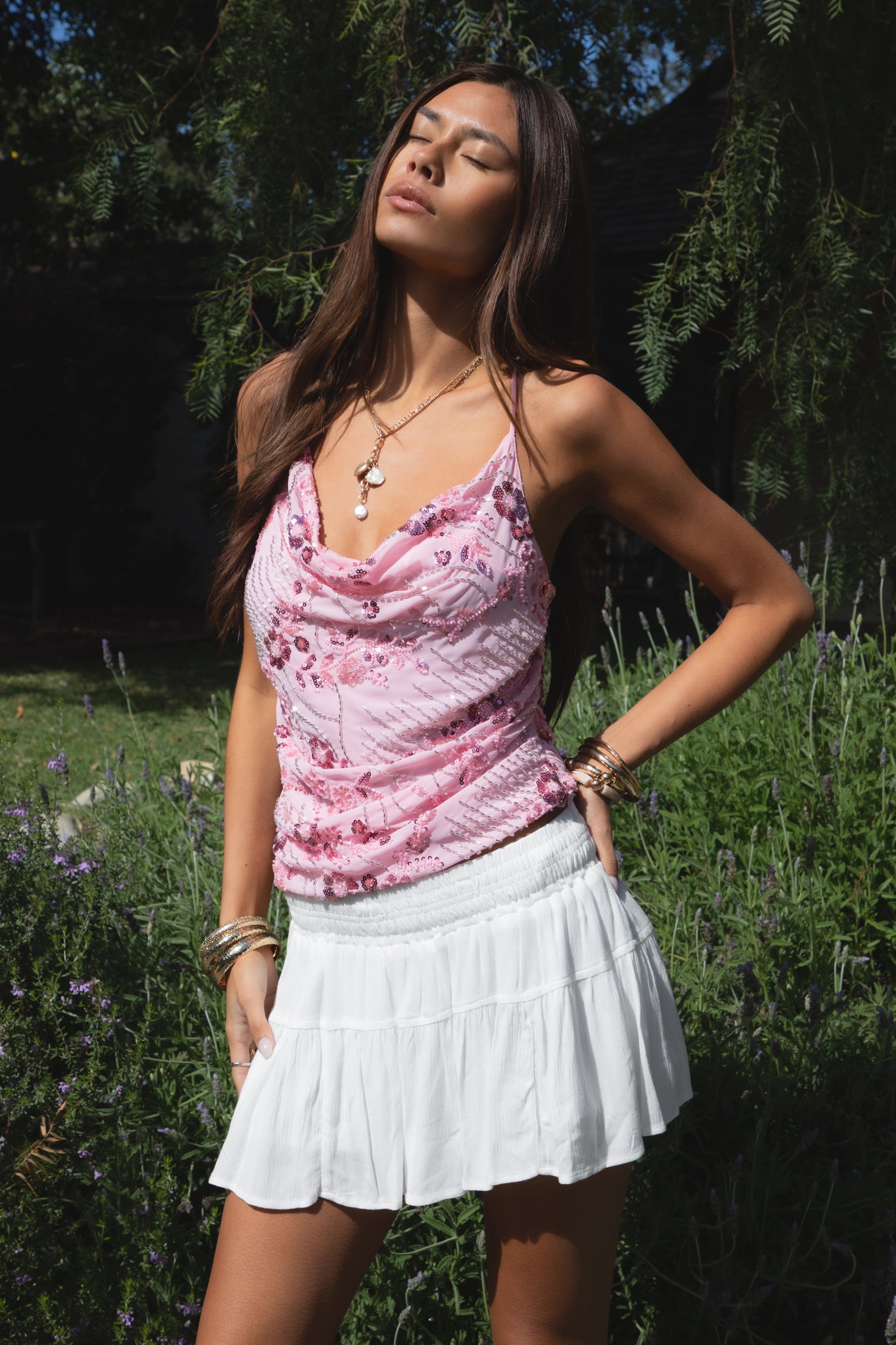 Woman wearing TIC TOC TL31684 AURYA chiffon sequin beaded cowl neck top featuring a draped cowl neckline, floral sequin and beaded embroidery, thin adjustable straps with cross back detail, fitted cropped silhouette, and asymmetrical hemline for a feminine festival and night-out look.