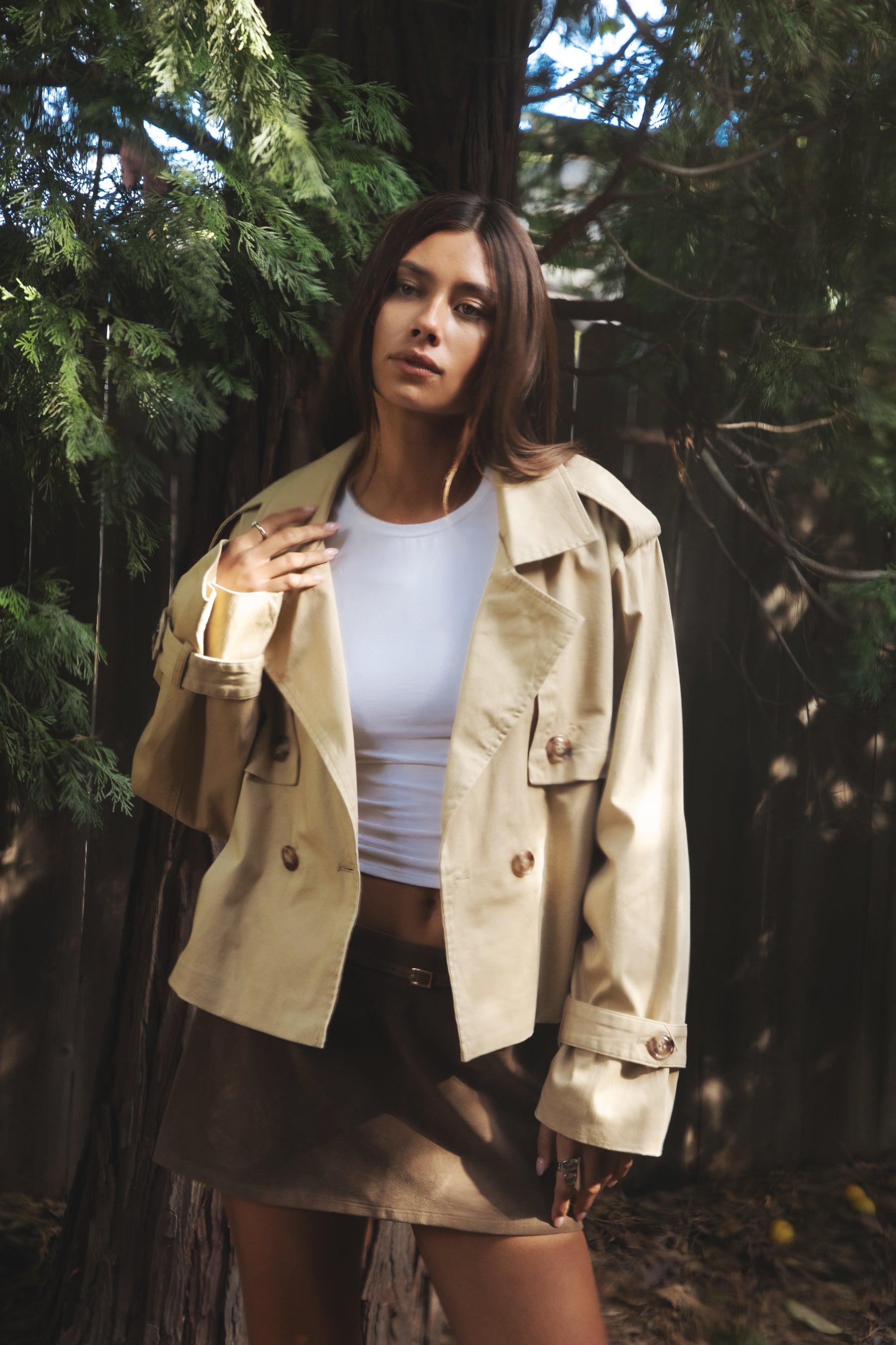 Woman wearing TIC TOC TT31828-MARAIS MARAIS oversized long sleeve cropped trench jacket featuring a double breasted front button closure, drop shoulder long sleeves with adjustable sleeve straps, removable thick self tie waist strap, and two loop holes on the back, finished with stripe voile lining inside, styled over a simple top and tailored bottoms for a Parisian chic, western-minimal layered look.