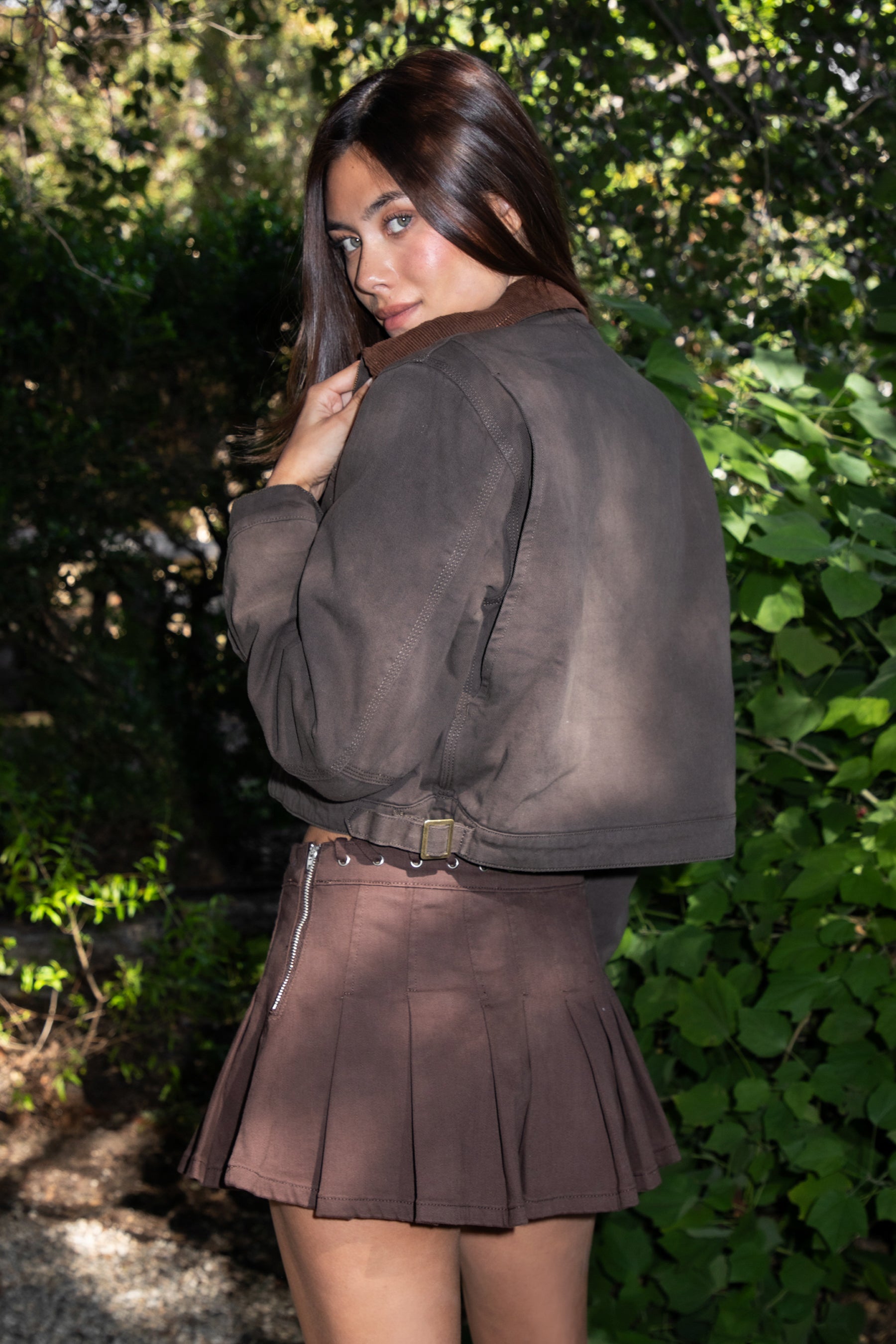 Woman wearing TIC TOC TT31861-FLINT FLINT washed solid twill cropped jacket featuring a front zip closure, contrast brown corduroy collar, two side pockets, a single chest zip pocket, snap button cuffs, and side buckle strap detail at the waistline, with satin quilted lining and light padding, styled over a simple top and denim for a western-inspired everyday transitional look.