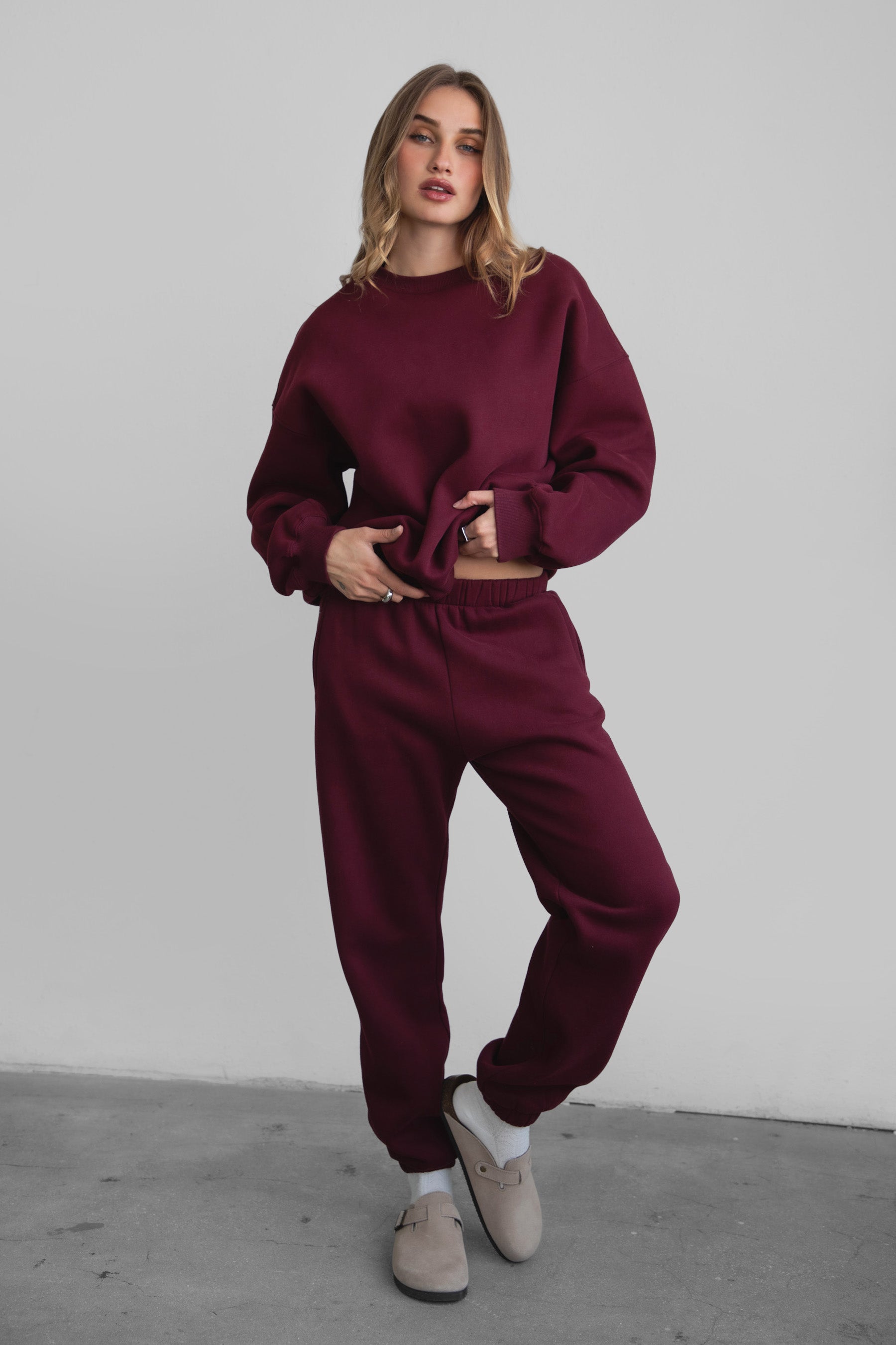 Woman wearing the TIC TOC PH26027 DOVE black cherry high waist sweatpants featuring an elastic waistband, deep side pockets, and tapered ankle hem with a matching top. 
