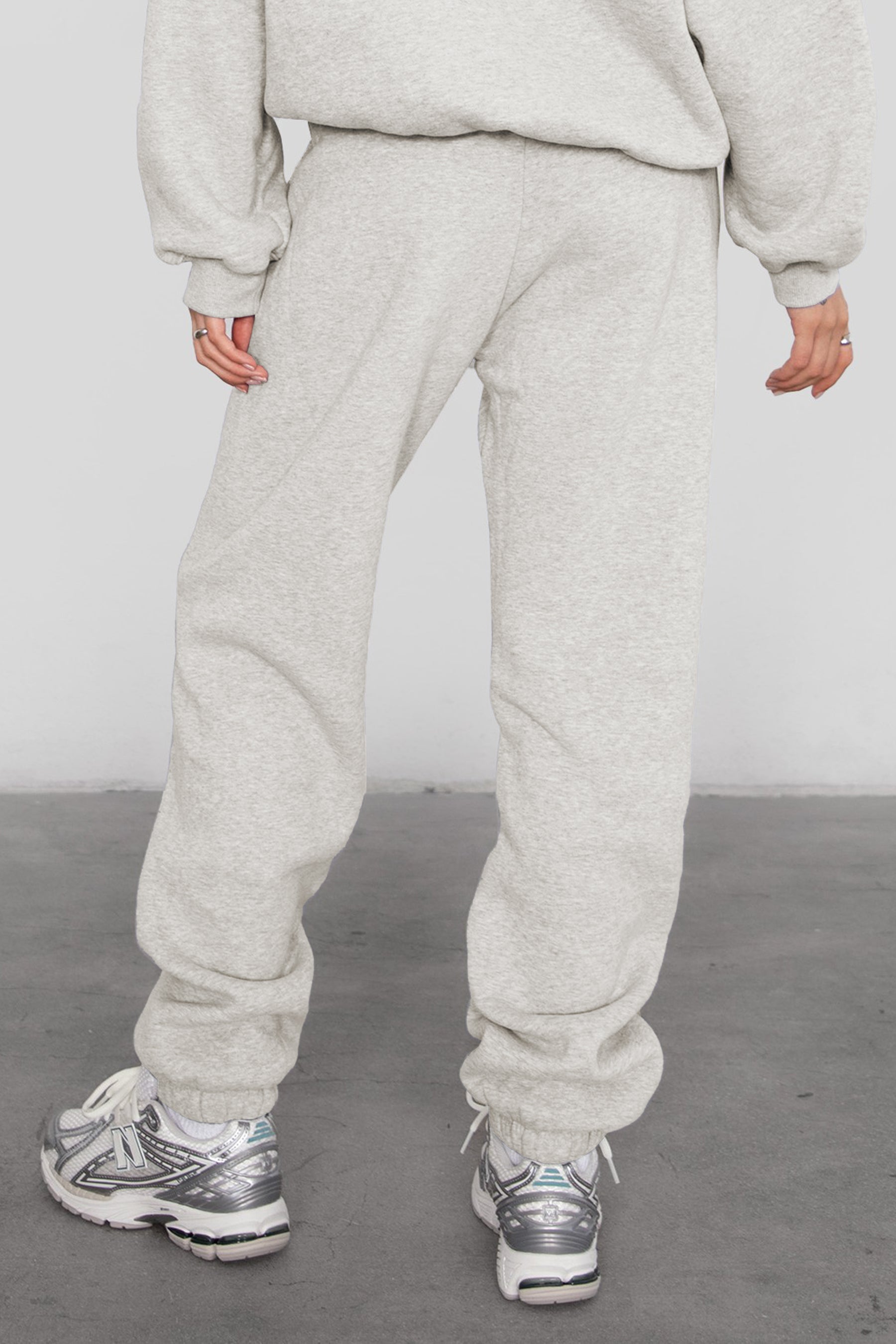 Woman wearing the TIC TOC PH26027 DOVE heather white high waist sweatpants featuring an elastic waistband, deep side pockets, and tapered ankle hem with a matching top. 