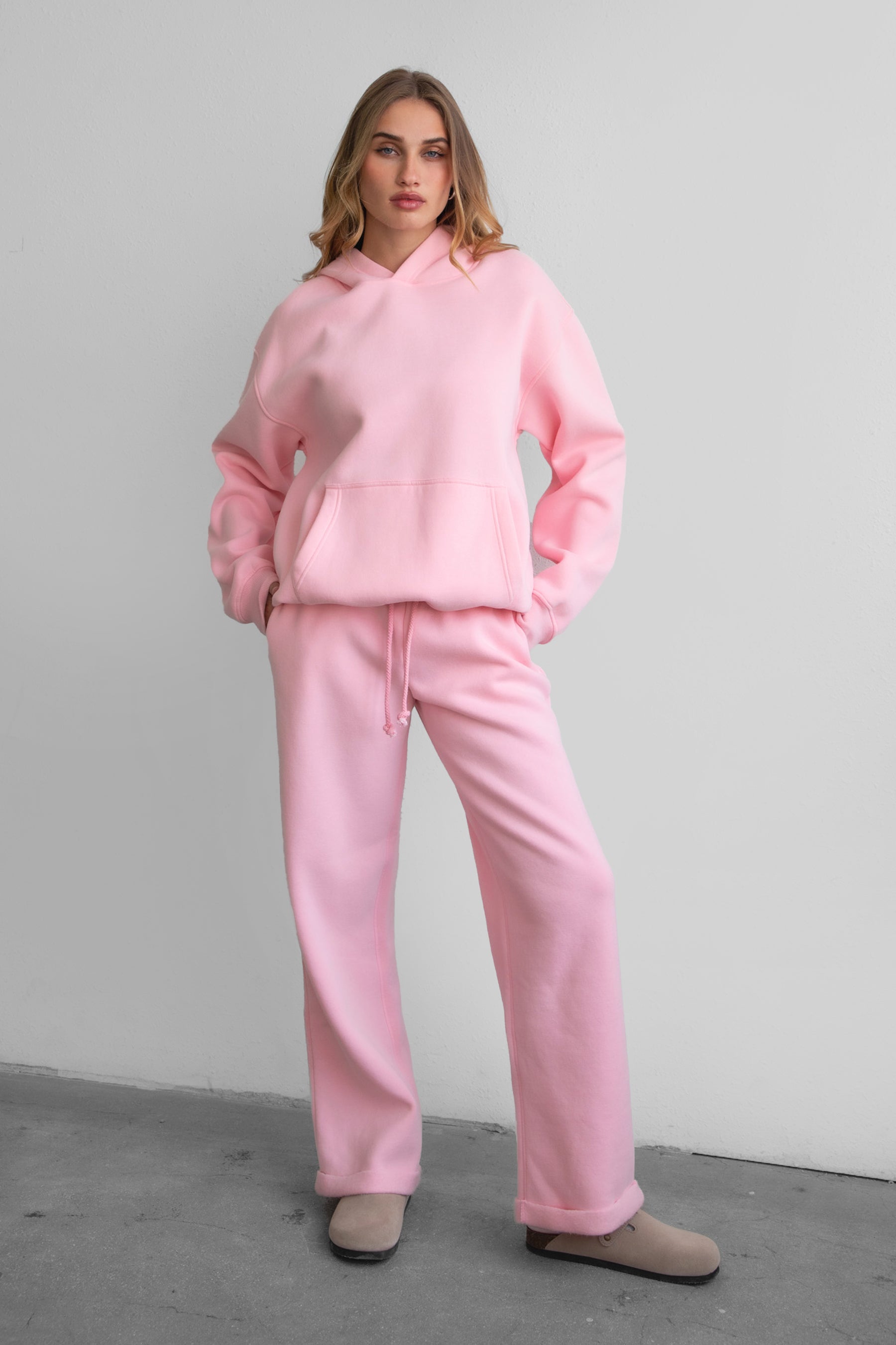 Woman wearing the TIC TOC PJ30241 LANI blush cloud fleece wide leg sweatpants featuring a straight leg silhouette, drawcord waistband, and side pockets paired with a matching hoodie.