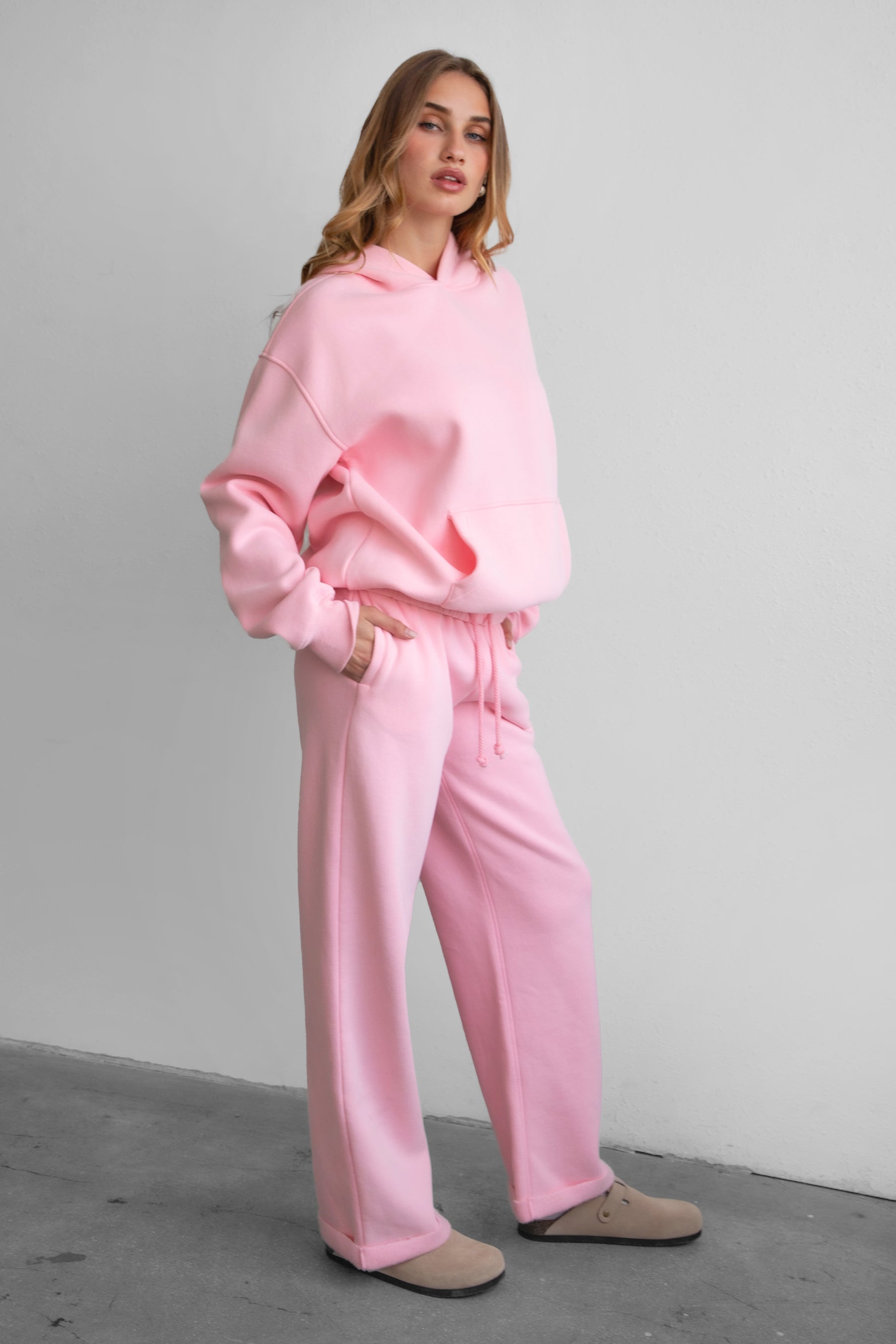Woman wearing the TIC TOC PJ30241 LANI blush cloud fleece wide leg sweatpants featuring a straight leg silhouette, drawcord waistband, and side pockets paired with a matching hoodie.