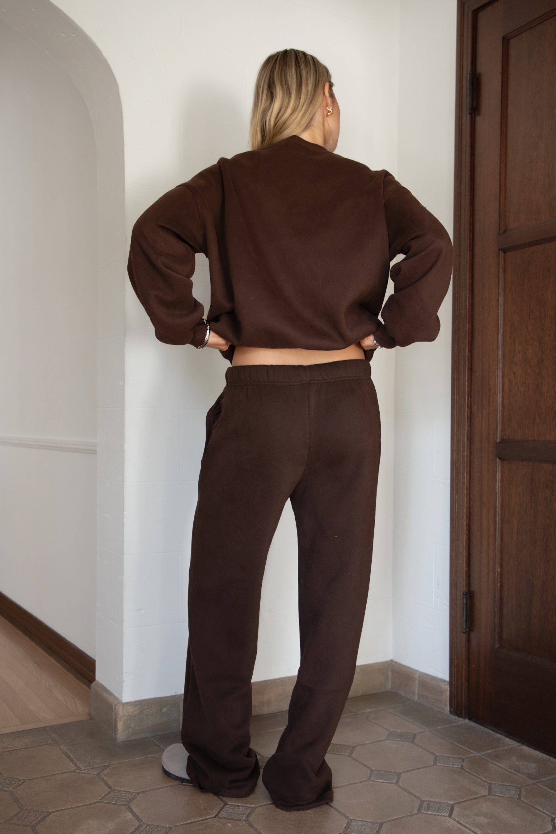 Woman wearing the TIC TOC PJ30241 LANI brown cloud fleece wide leg sweatpants featuring a straight leg silhouette, drawcord waistband, and side pockets paired with a matching sweater. 